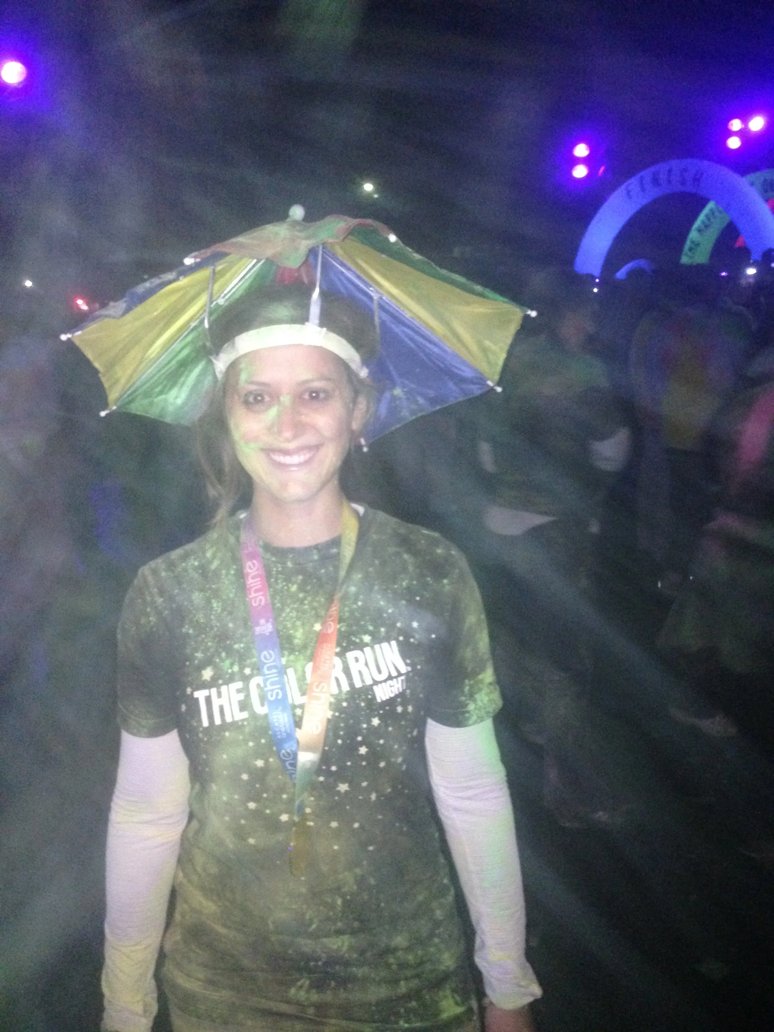 Image of Jessica Ghantous with umbrella hat, wearing medal and Color Run t-shirt.
