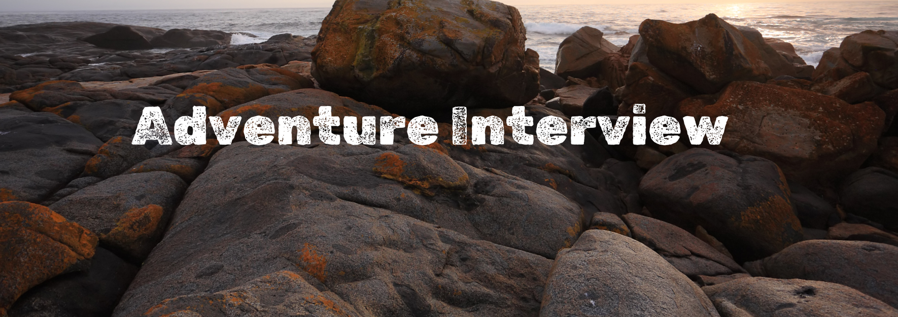 The words "Adventure Interview" in white with boulders and beach in background.