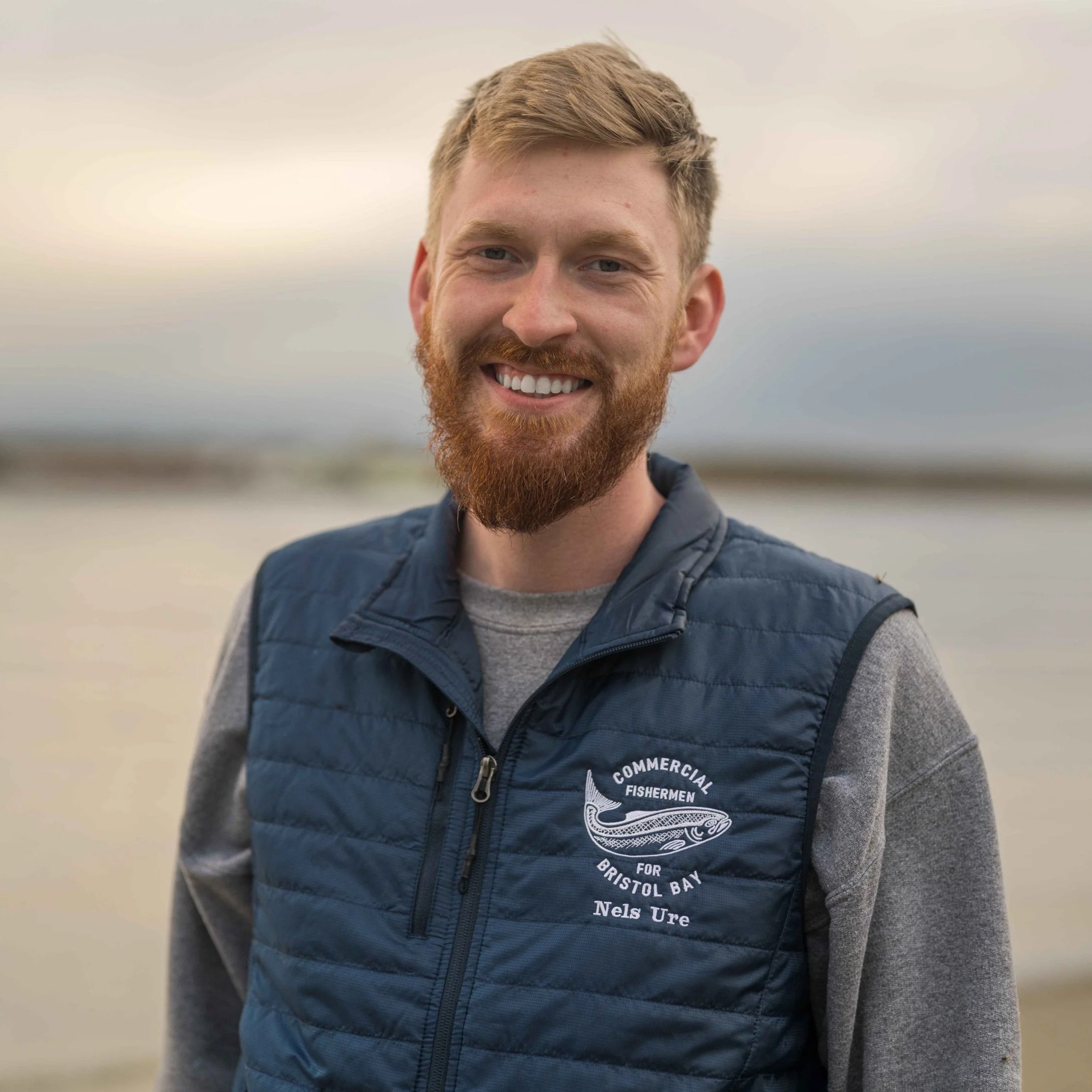 Man fishing for salmon with baby on his back