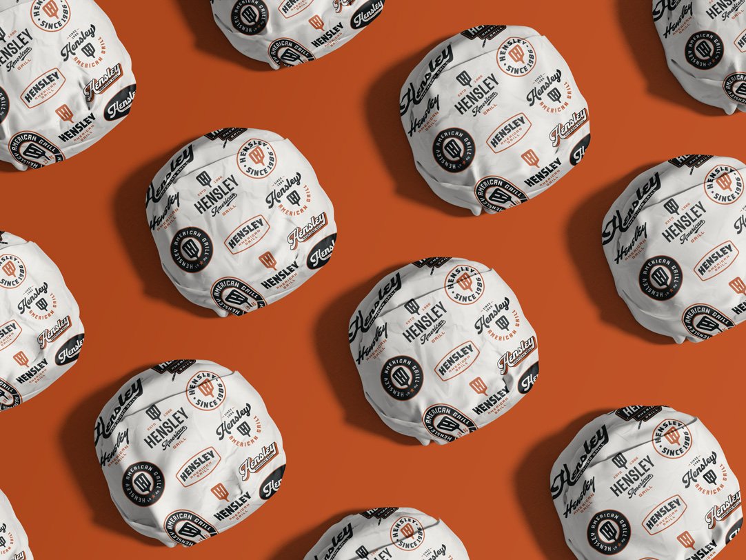Hensley American Grill burger wrap packaging pattern using the restaurant logo system and vintage badge marks.