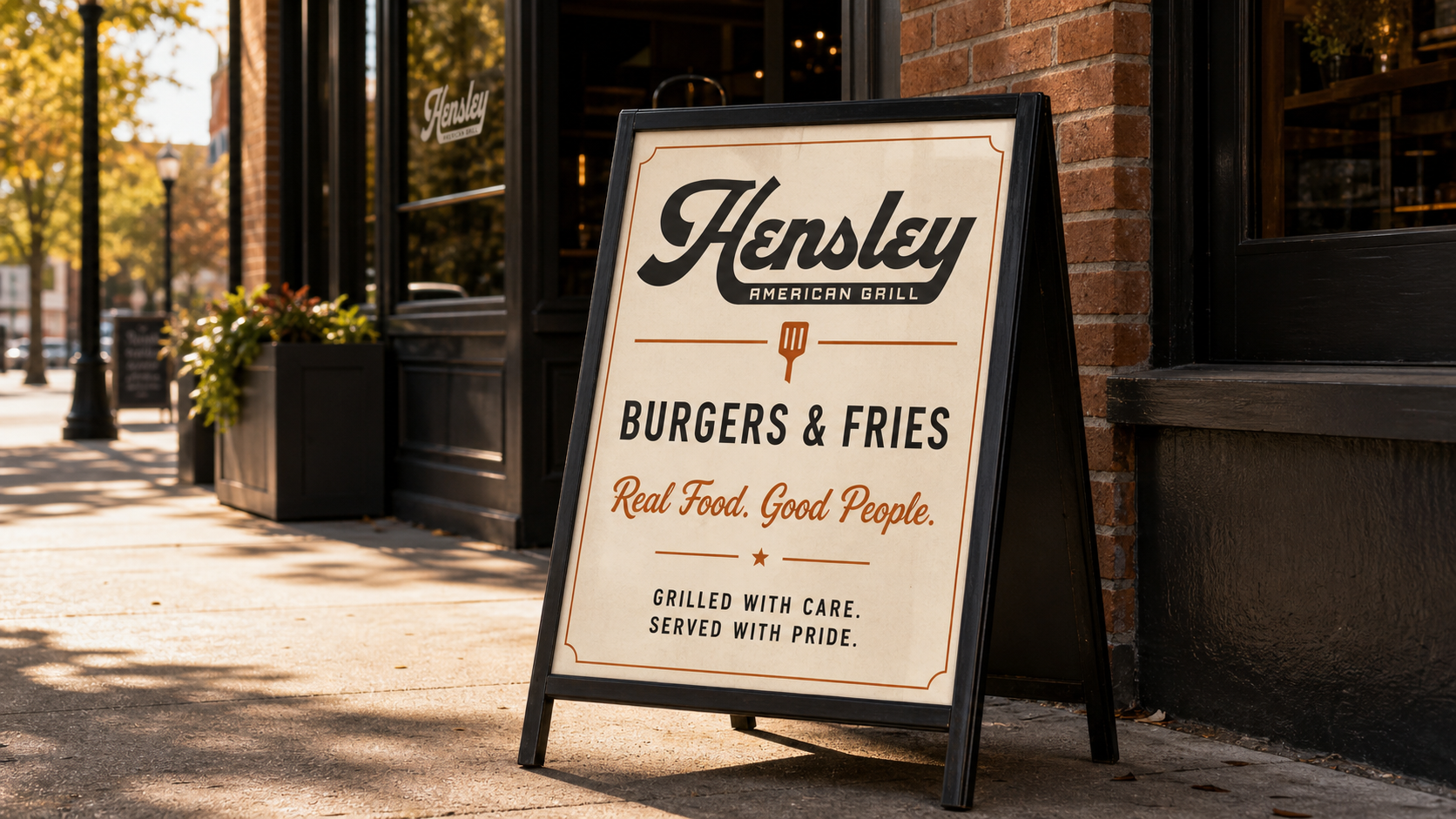 Hensley American Grill sidewalk sign promoting burgers and fries with vintage-inspired restaurant typography