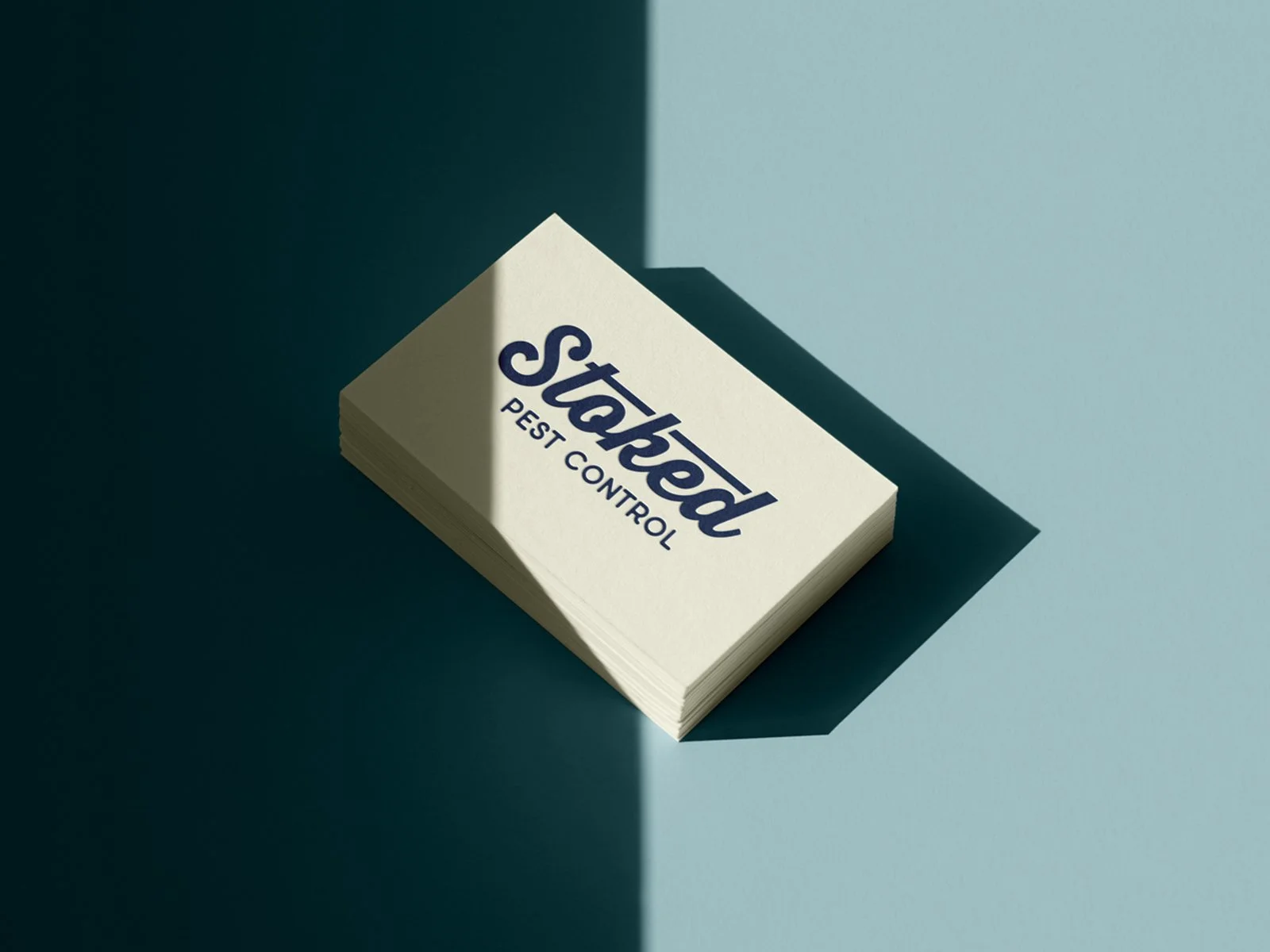 Stoked Pest Control business card mockup featuring navy logo on warm cream paper with retro brand colors.