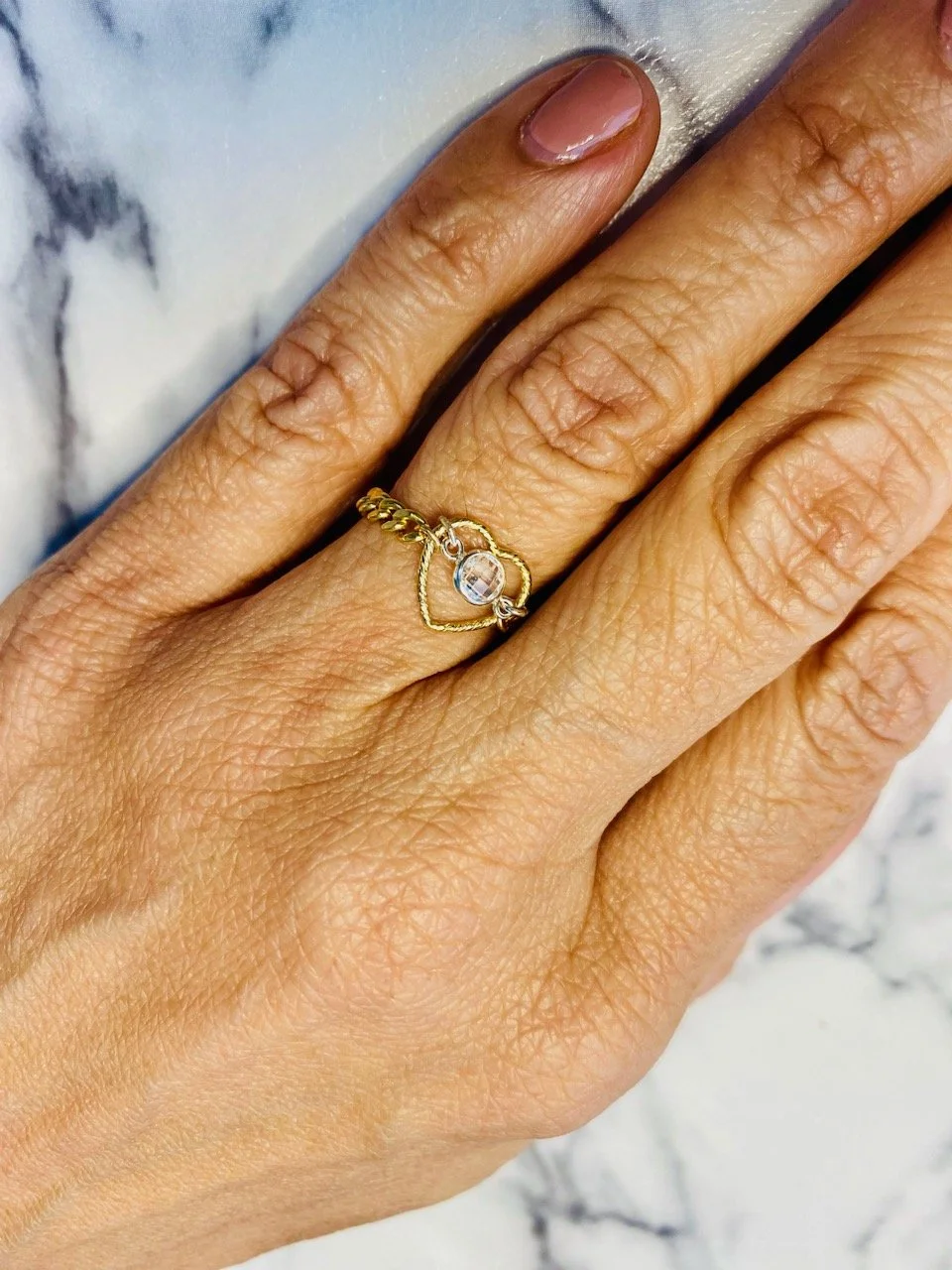 Woman's gold ring with a heart and diamond charm