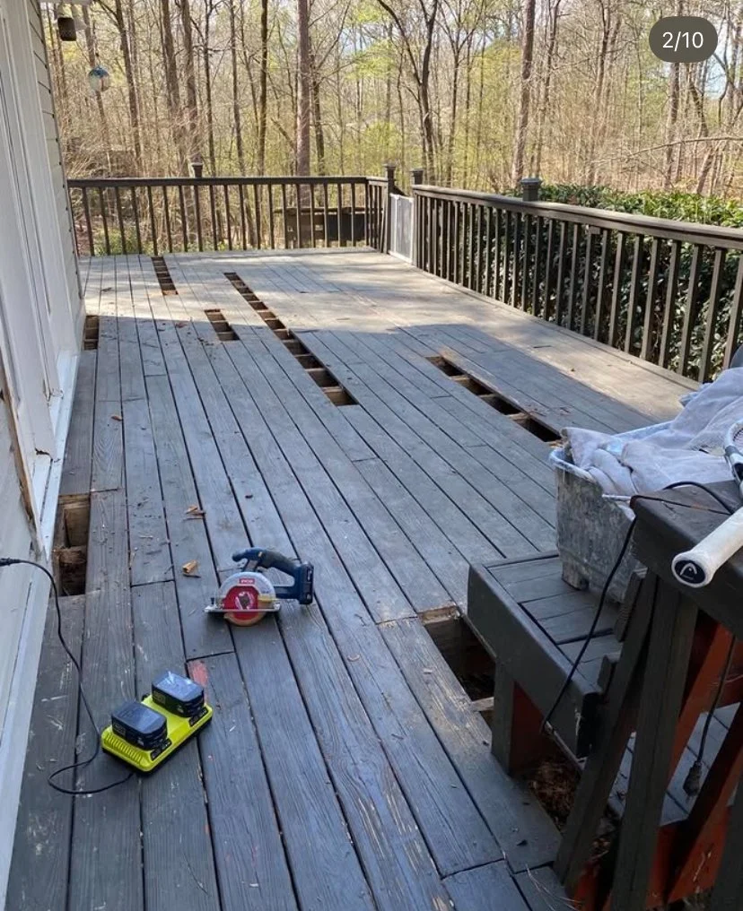 Back deck in the process of being repaired, with missing wood planks, partly finished with new planks, and tools on the floor.