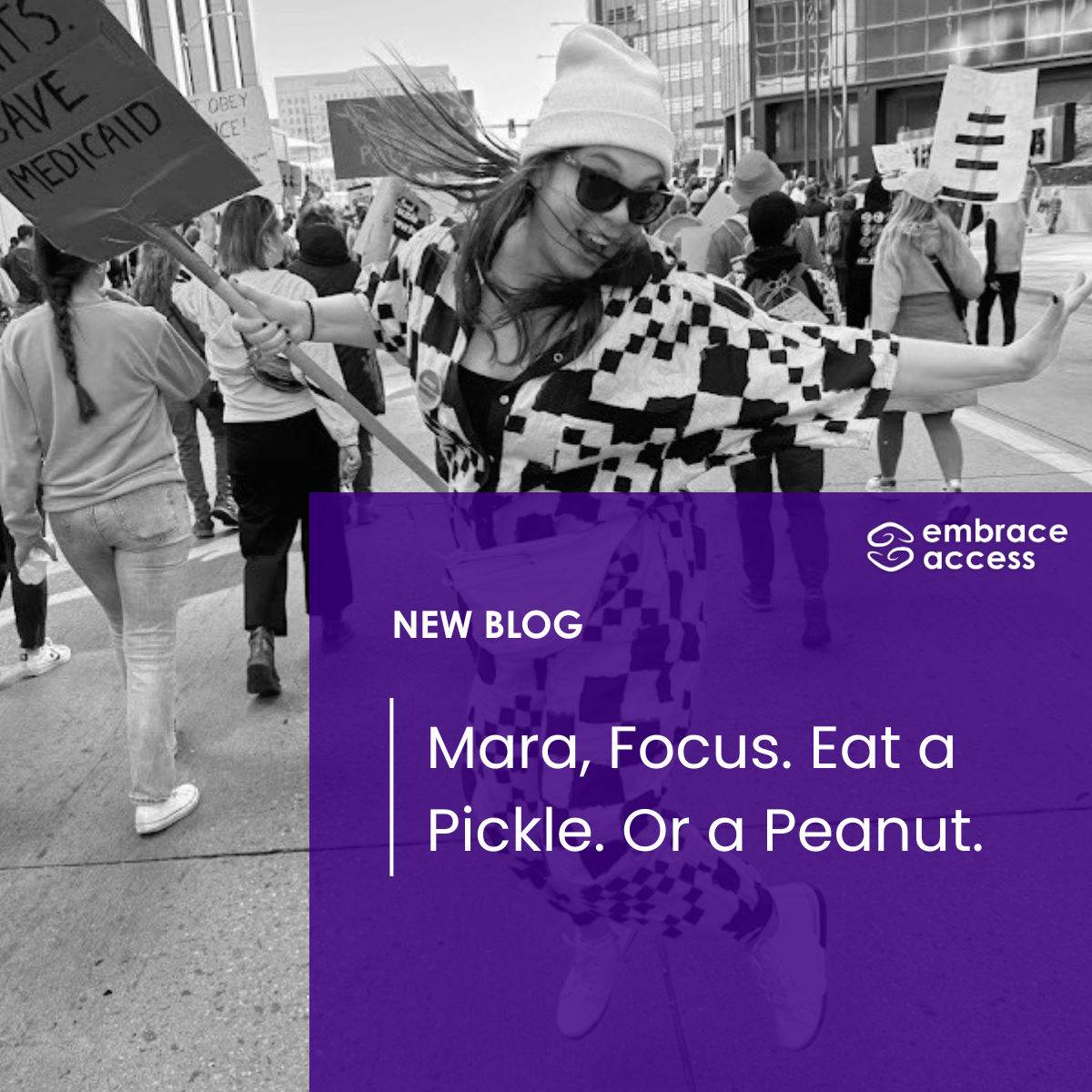 Mara is jumping mid-air and smiling at a protest. She wears a checkered jumpsuit, a beanie, sunglasses, and a cardboard sign reading "Save Medicaid." The image is black and white with a purple square on the bottom with the title of the article.