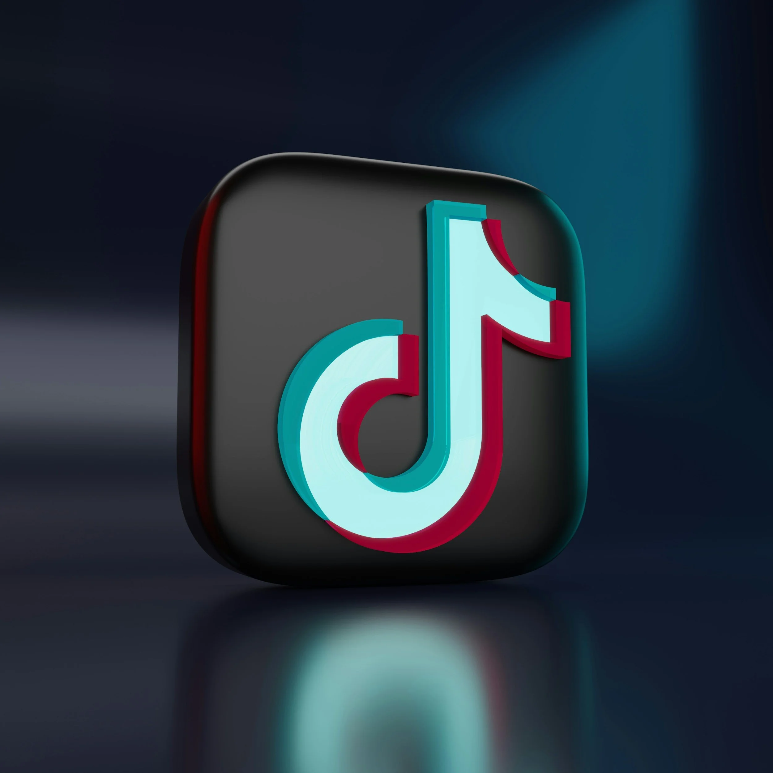 Logotipo tridimensional de la aplicación TikTok sobre un fondo oscuro.