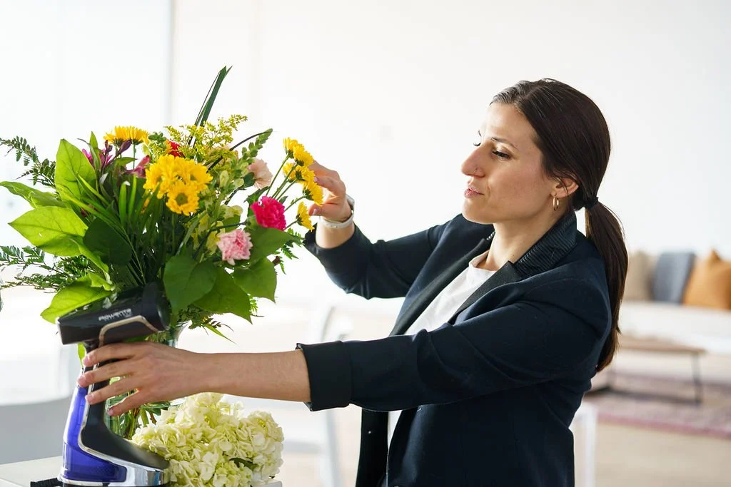 Christina Andreola, celebration of life planner and founder of New Narrative Events, arranging florals on-site at an event