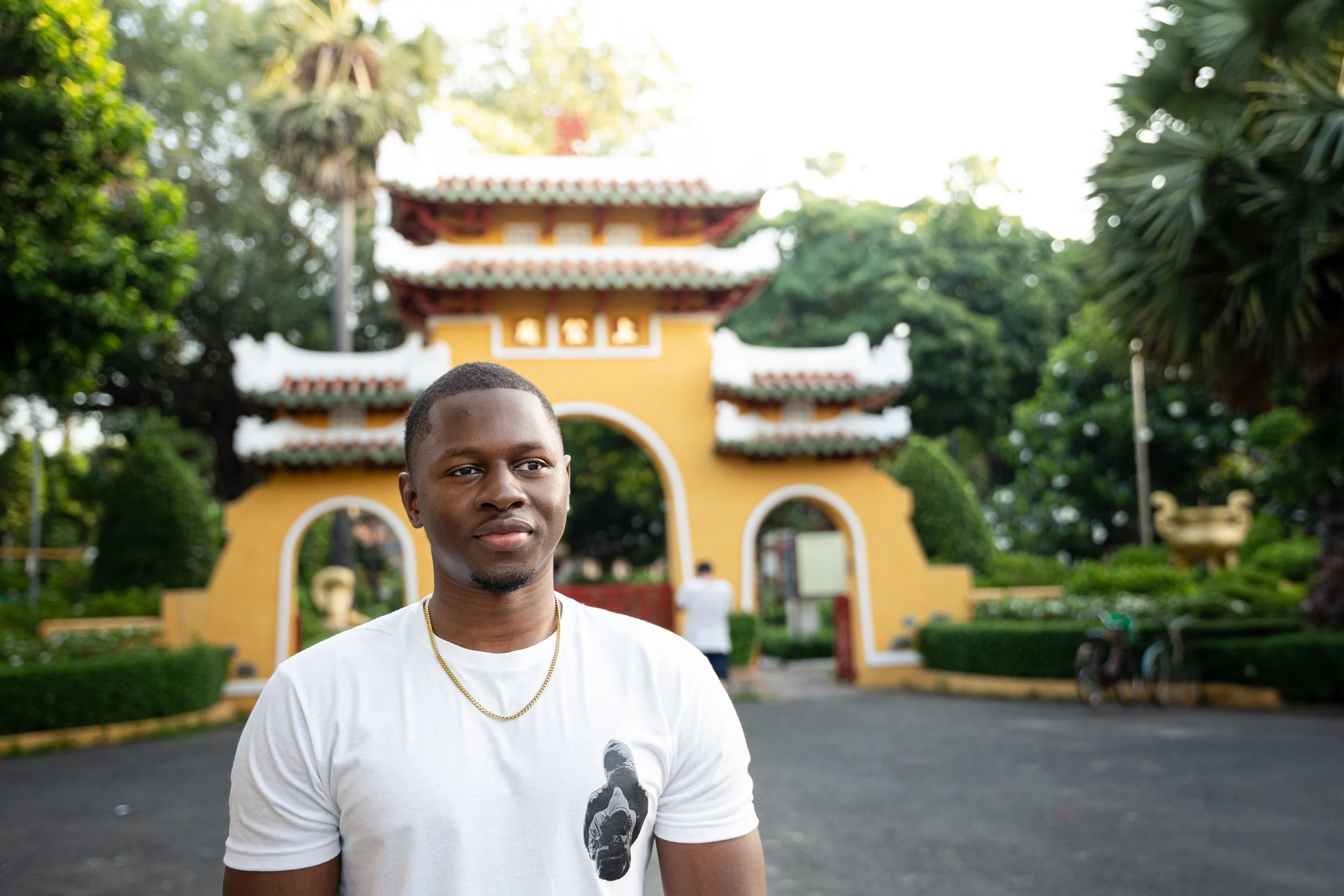 A man stands in front of a temple gate in Ho Chi Minh City.