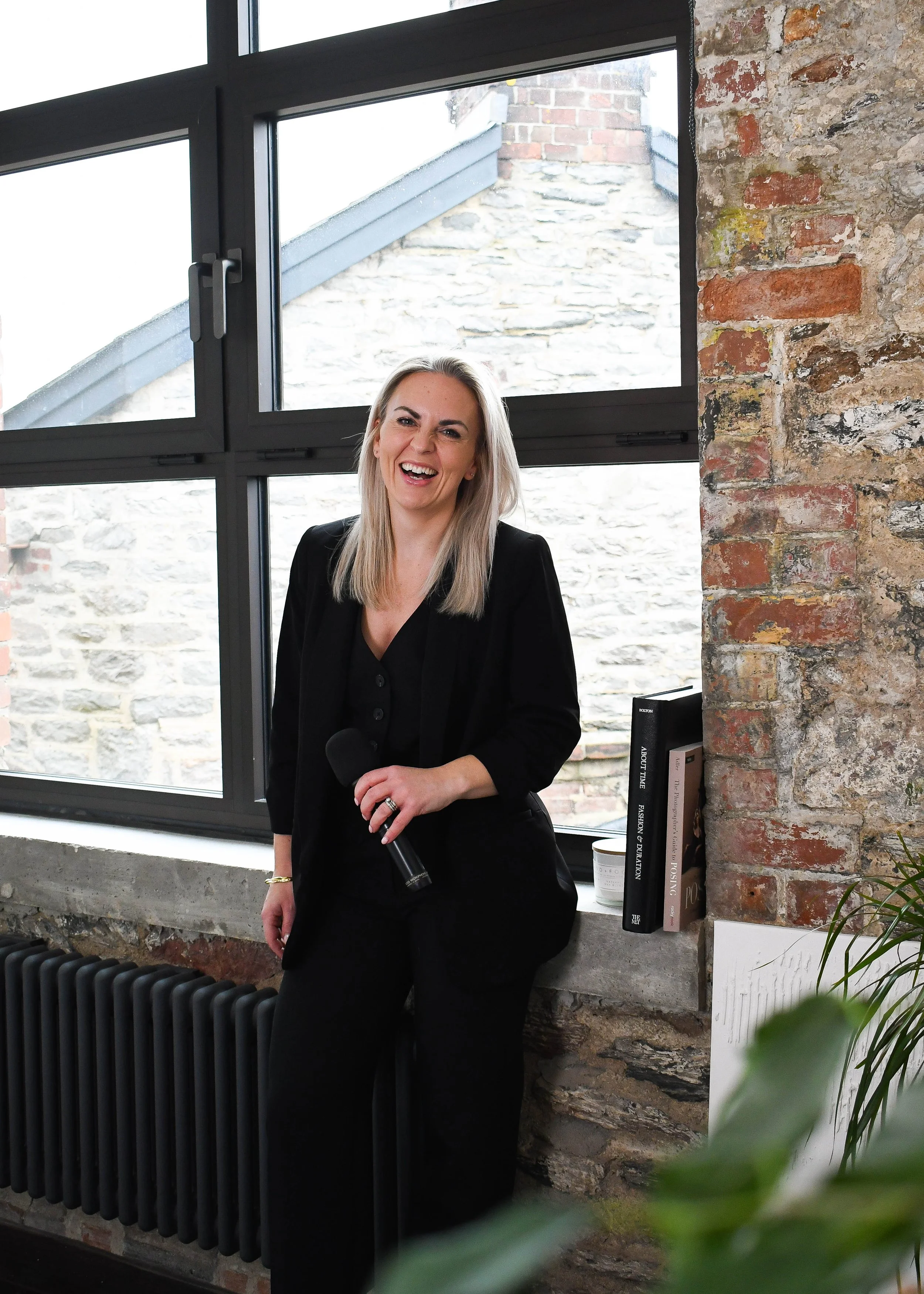 Jess Wiggins laughing indoors during a branded photoshoot.