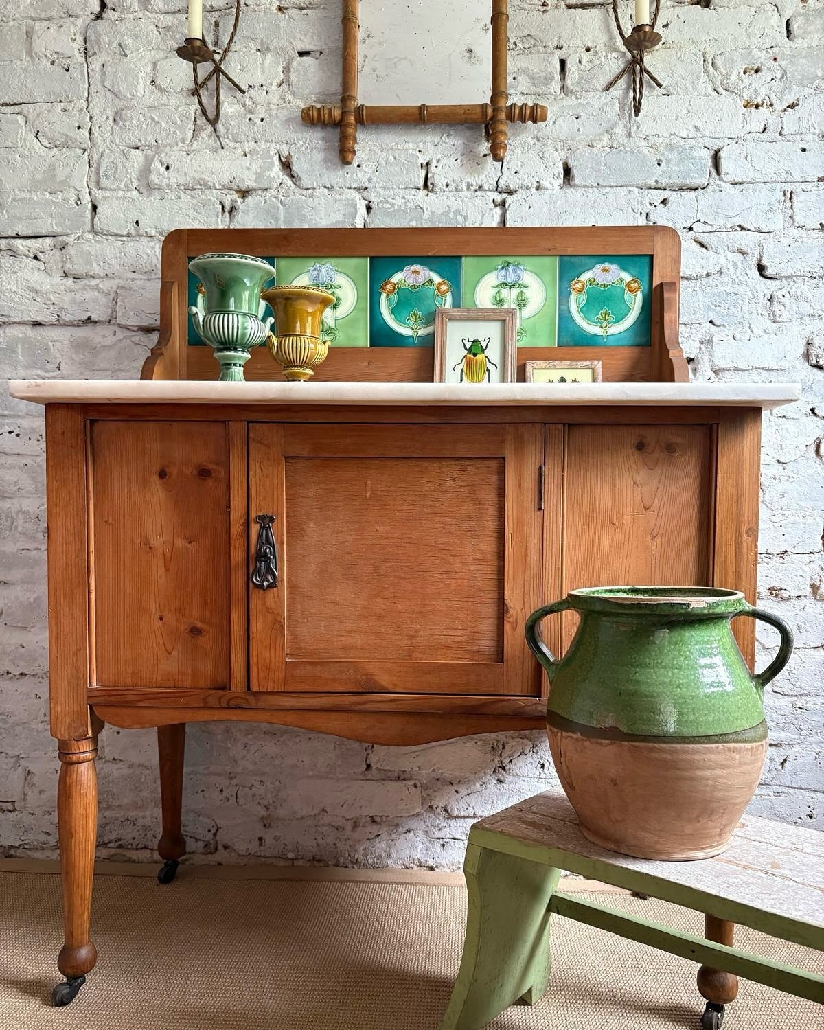 A charming antique pine washstand.. the vintage floral tiles add a touch of whimsy, while the sleek marble top brings a dash of modernity. Pops of green breathe life into this classic piece, creating a perfect blend of antique charm and fresh style ?