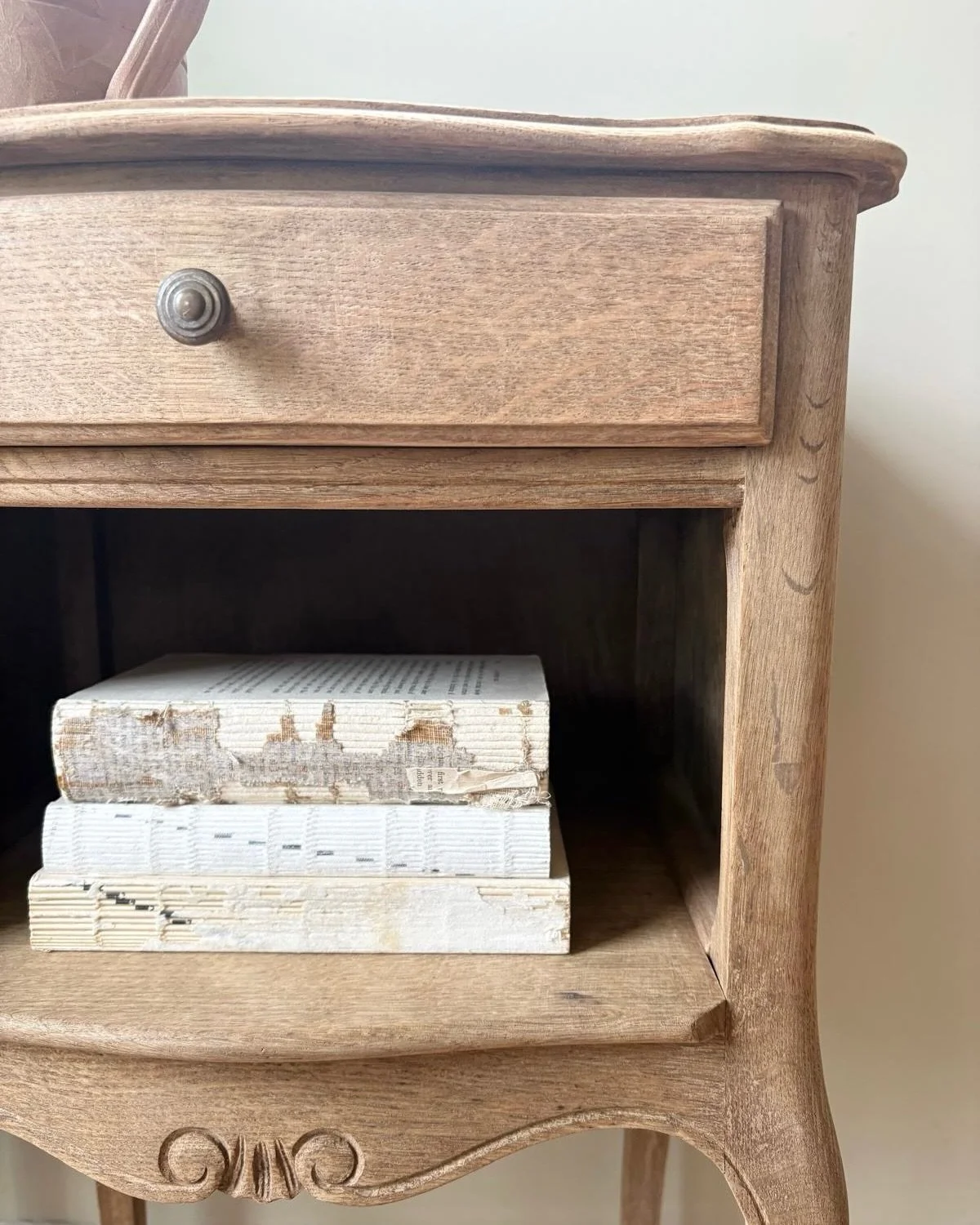 An exceptional pair of French bedside tables, beautifully crafted in a light natural oak finish. Graceful cabriole legs, delicate decorative detailing and softly curved lines create a timeless silhouette that feels both refined and effortless. Their 