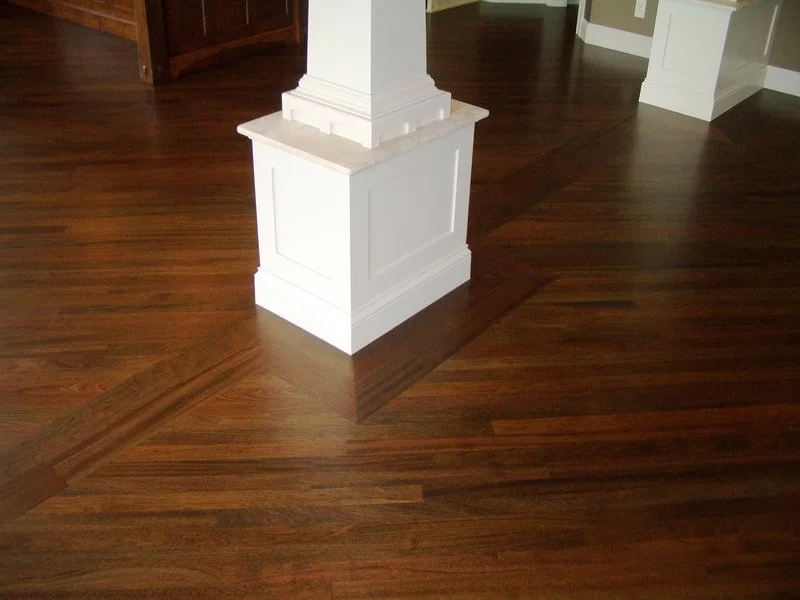 Dark hardwood floor with a white column in a spacious room.