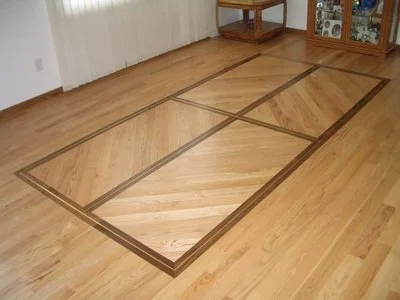 Wooden floor with decorative inlay pattern in a room with furniture.