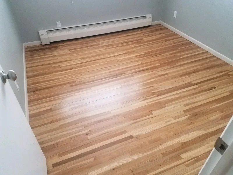 Empty room with wooden floor and baseboard heater