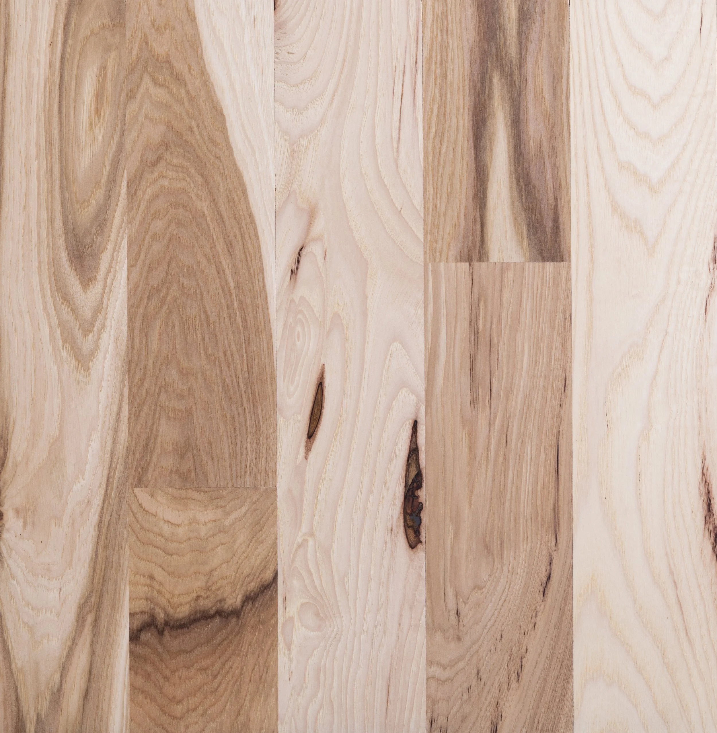 Close-up of light wooden flooring with natural grain patterns and knots.