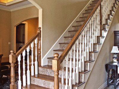 Interior staircase with wooden handrail and white balusters in a home setting.
