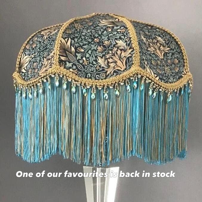 The Snakeshead Lampshade

Handmade using the iconic William Morris Snakeshead fabric, this decorative lampshade brings a touch of Victorian elegance to any interior. The rich turquoise tones are finished with layered fringe and delicate trim, creatin