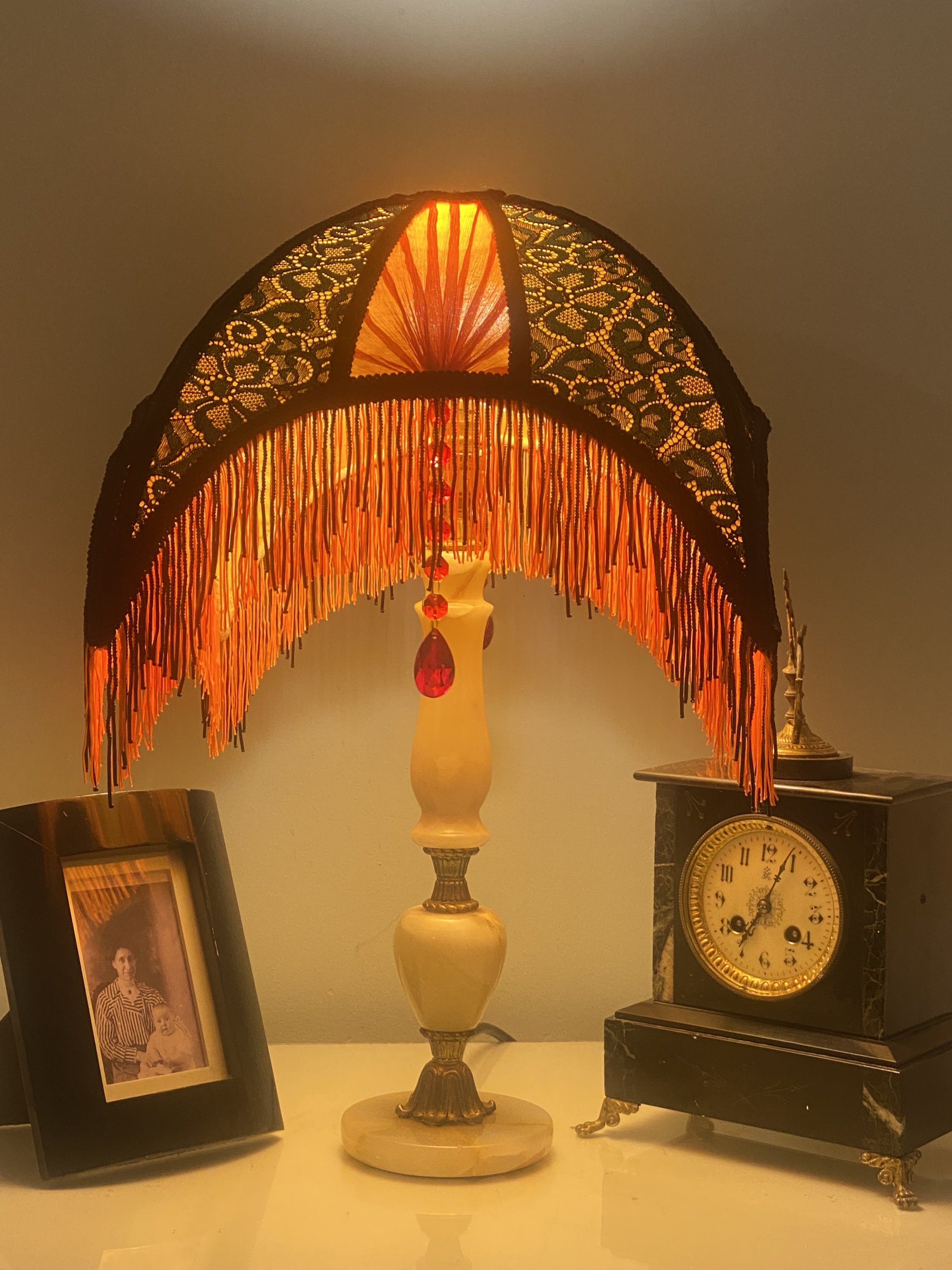 Art deco fringed lampshade in a crescent moon shape, orange silk, green and black lace, scarlet pleated panels , lit up 4