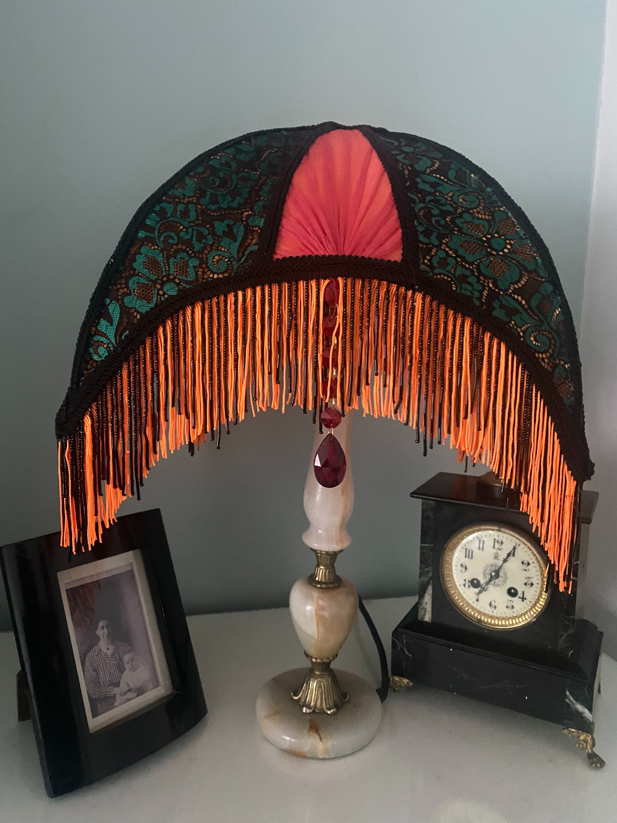 Art deco fringed lampshade in a crescent moon shape, orange silk, green and black lace, scarlet pleated panels , orange and black fringe
