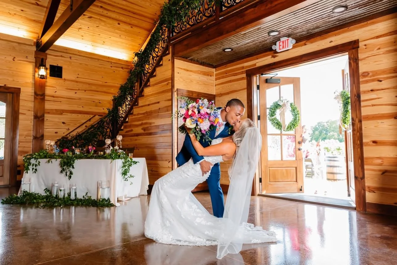 Groom dips bride at Twisted Vines Vineyard