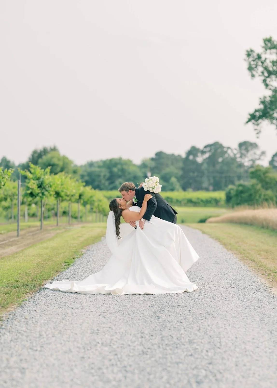 Connor Stephenson Photogrpahy: Bride and groom kissing on dirt road.
