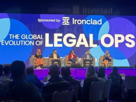 Panel discussion on "The Global Evolution of Legal Ops" sponsored by Ironclad, featuring five speakers seated on stage in front of an audience.