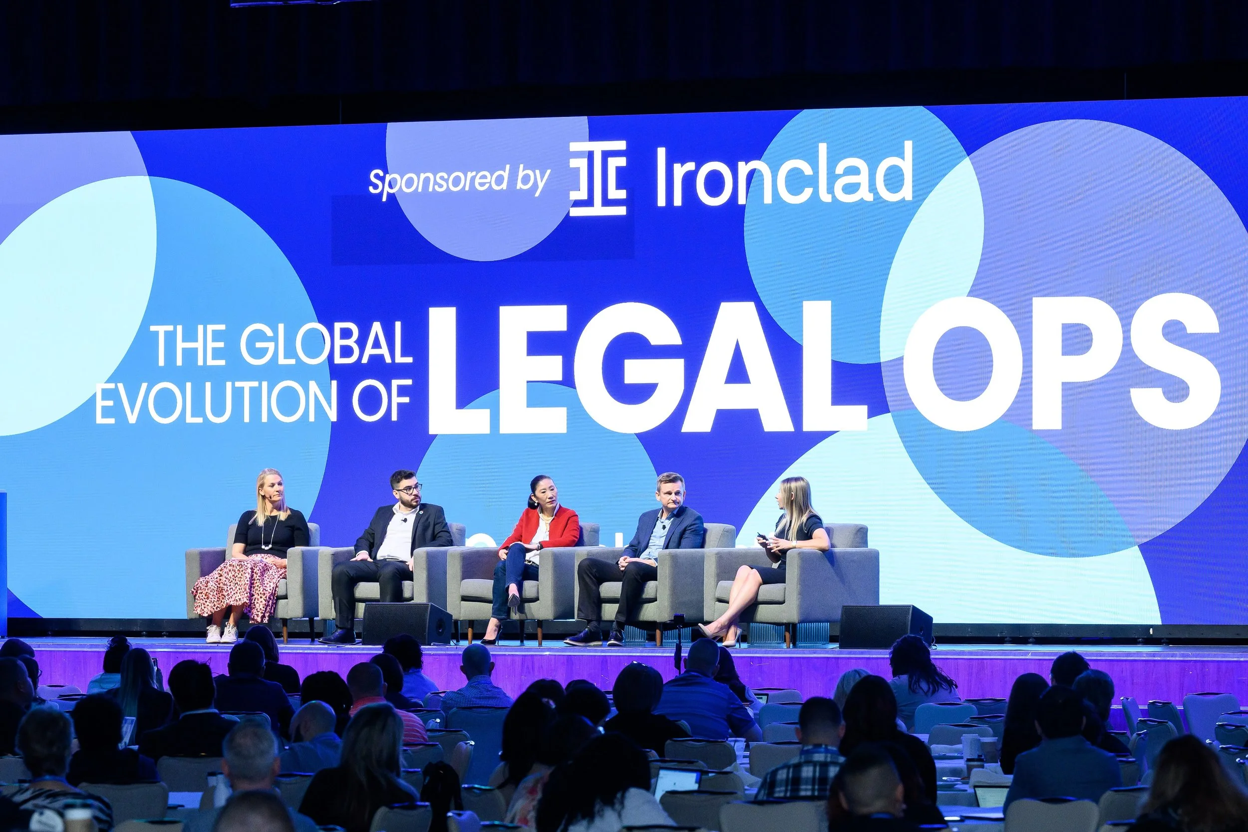 Panel discussion on 'The Global Evolution of Legal Ops,' sponsored by Ironclad, with five speakers seated on stage facing an audience.