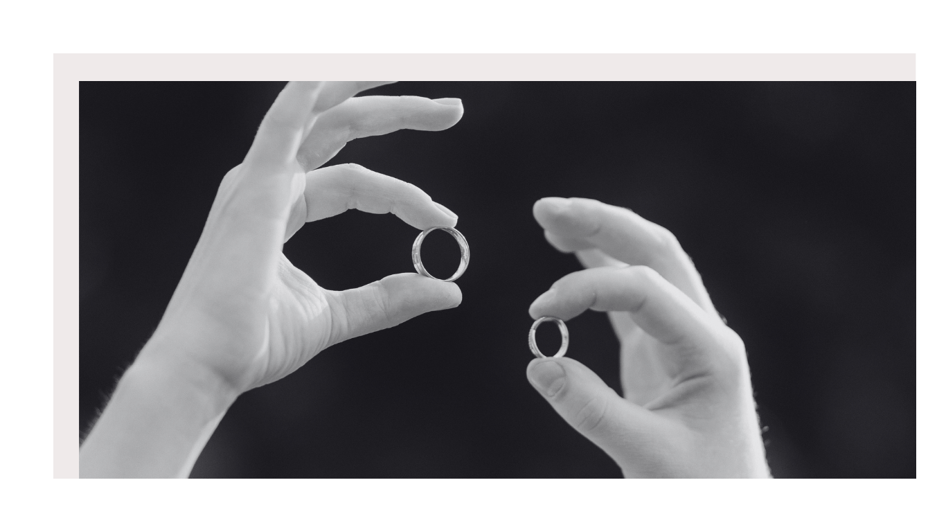 Husband and wife holding their wedding rings