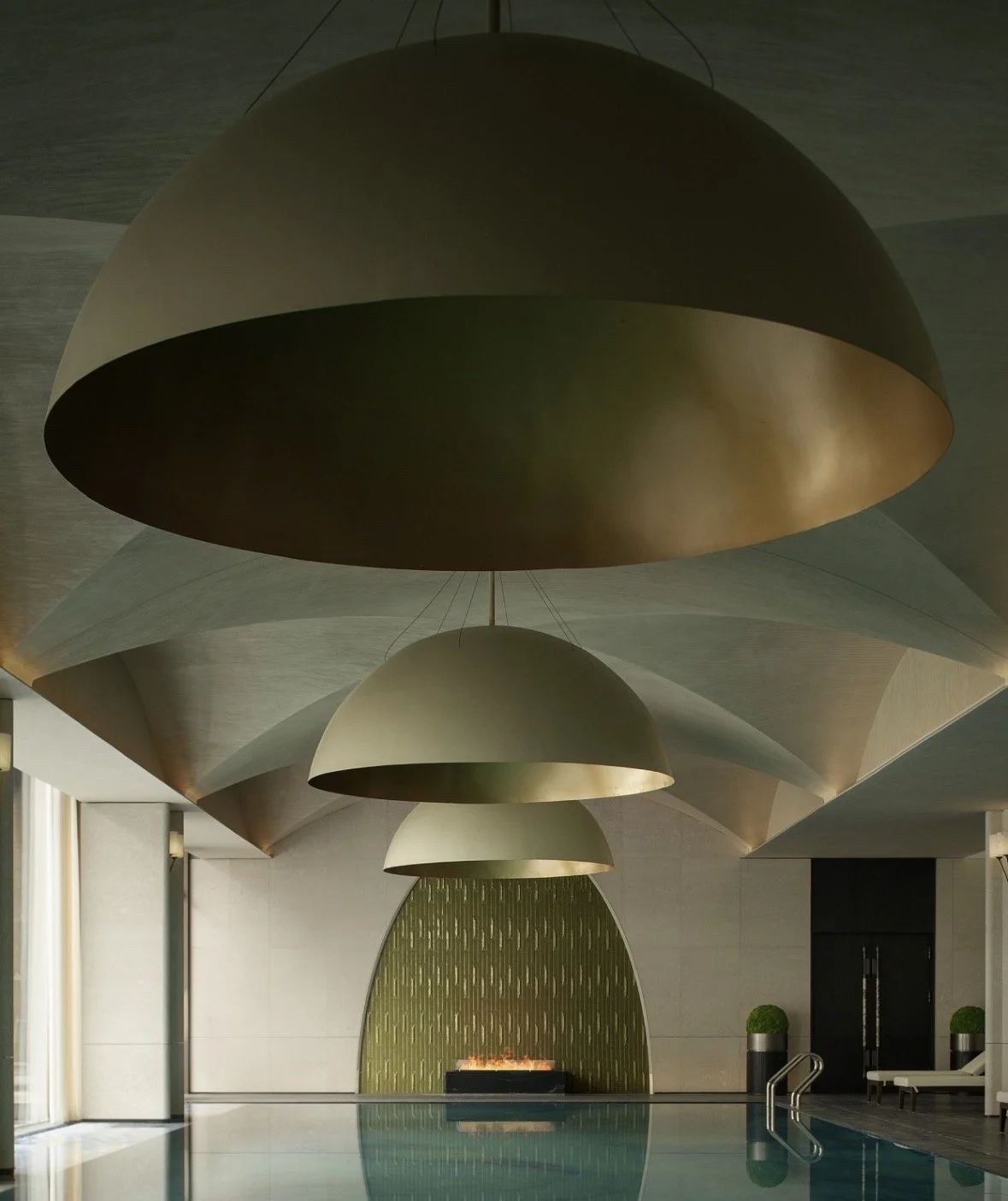 A decorative gold perfume bottle with a ball-shaped cap sits among an arrangement of purple, white, and violet flowers.