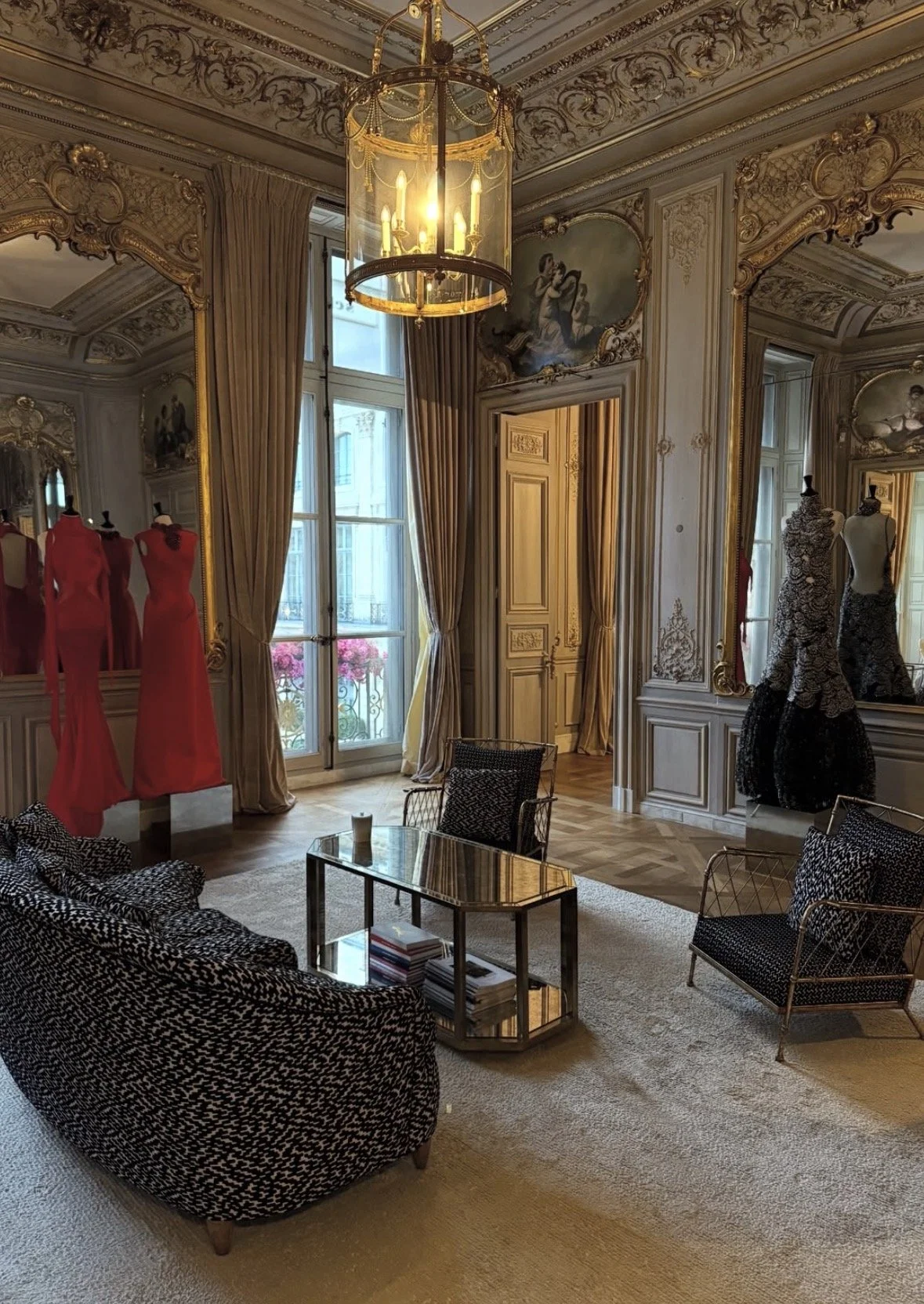 Luxurious Louis Vuitton display with a giant clock featuring the LV logo, handbags, statues, and snow, illuminated at night.