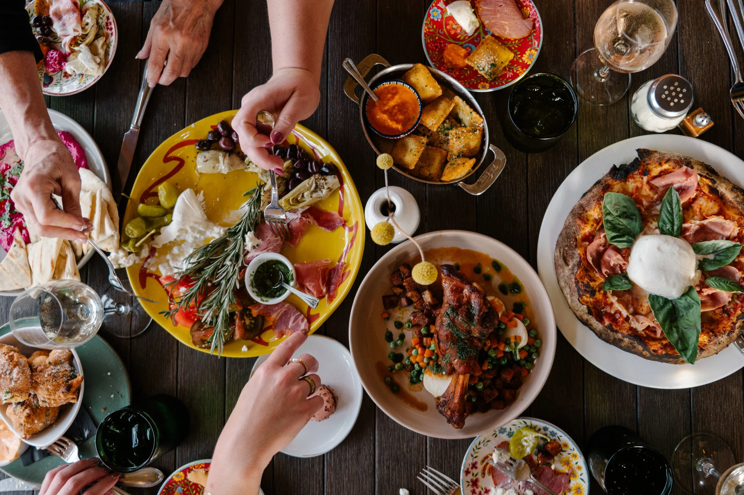 Wood-fired pizza and drinks served outdoors on Hugo’s patio.