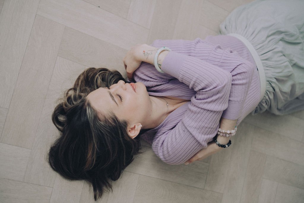 Catarina lying down bracing herself with eyes closed