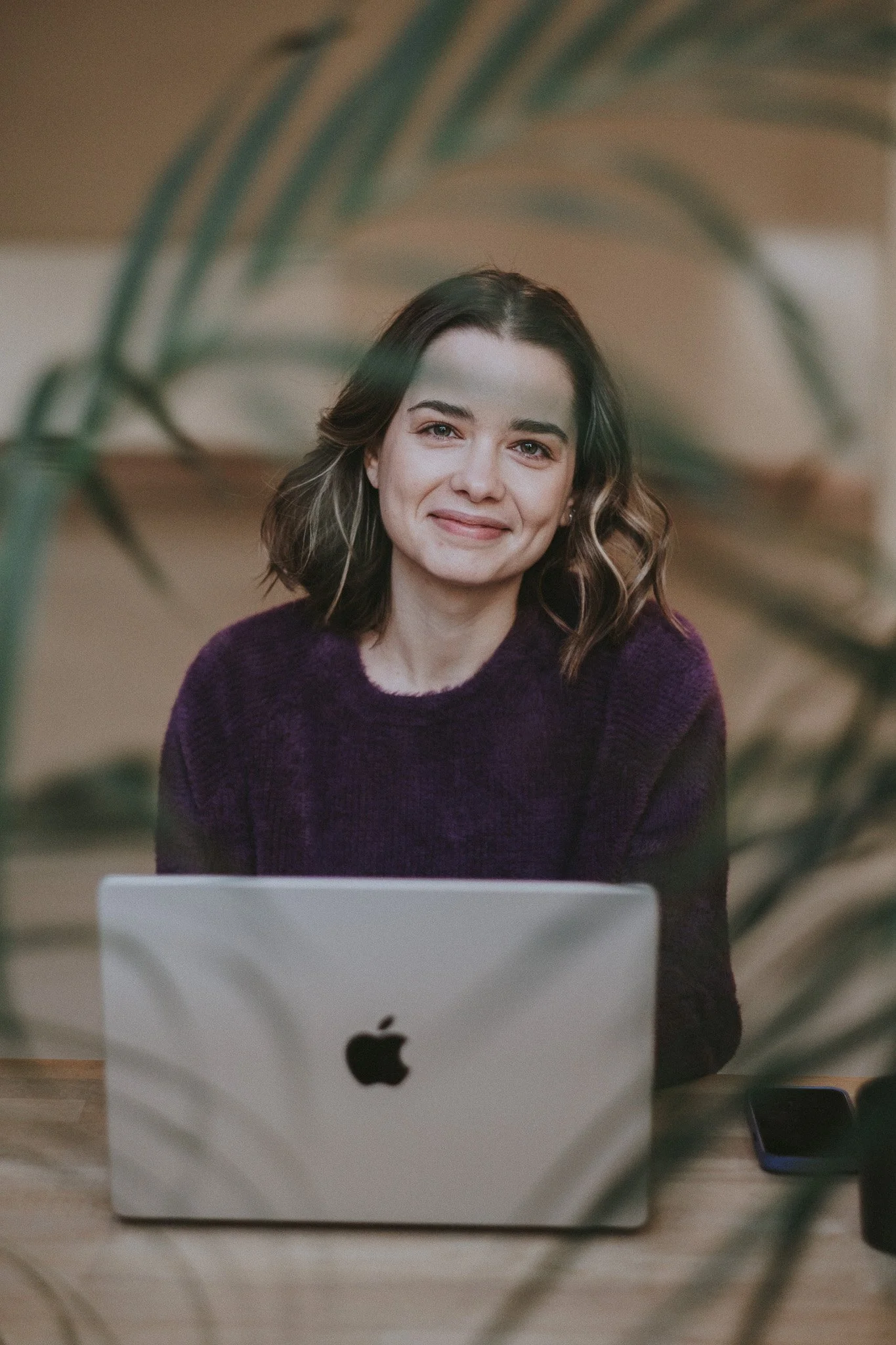 Catarina smiling at the camera in front of her laptop