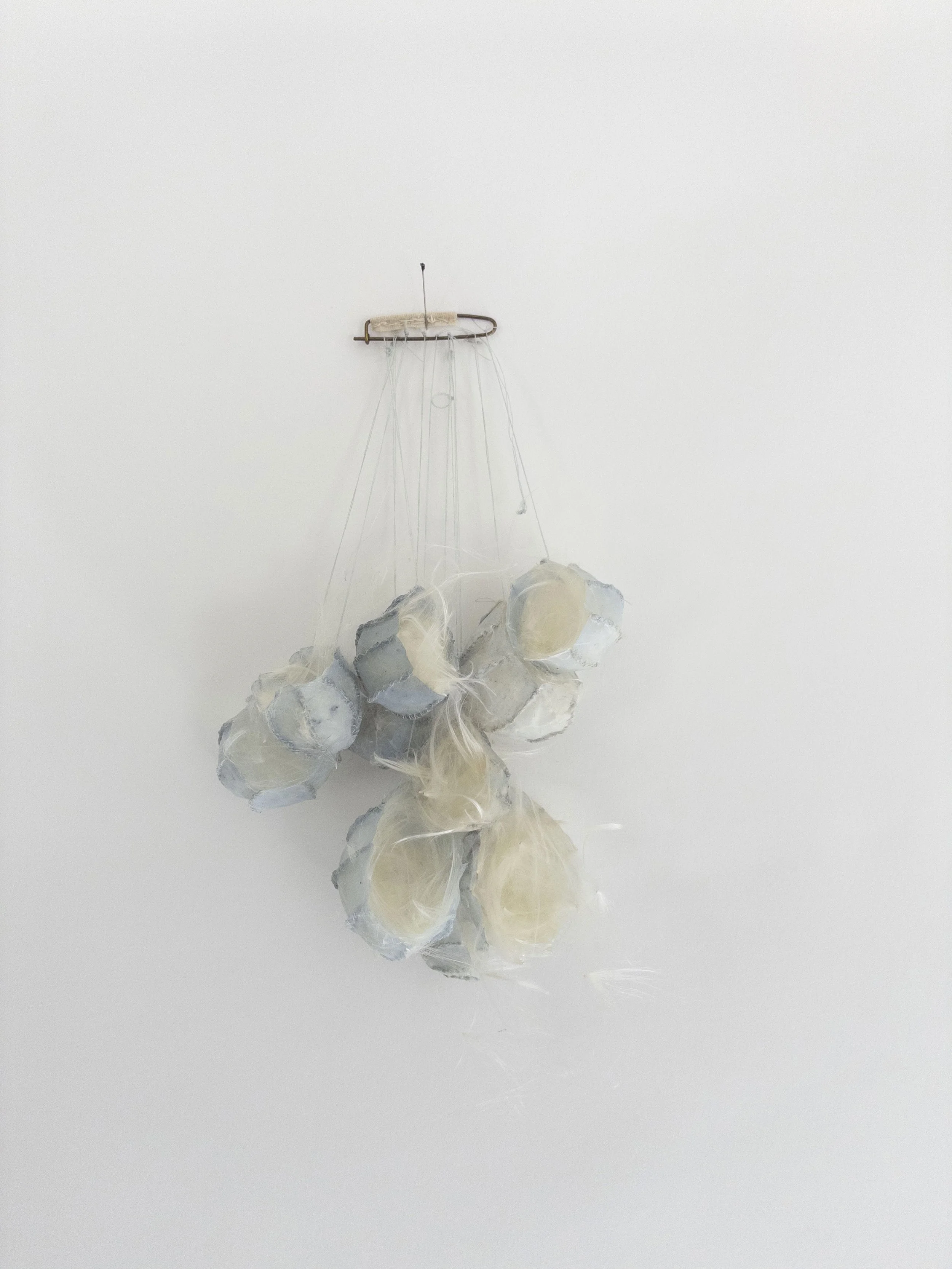 Adrift, 2017-2026, silk, beeswax, milkweed floss, cotton, metal,10 x 5 x 3 inches
