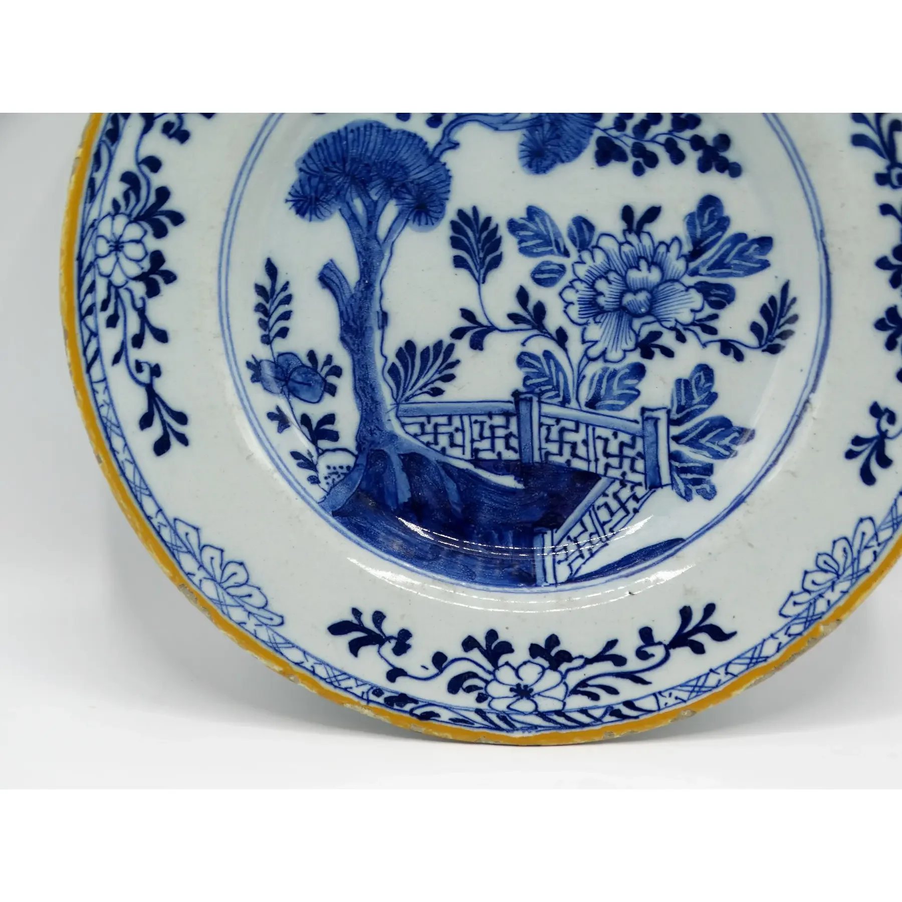Hand painted foliate and geometric rim on 18th-century Dutch Delft chinoiserie plate.