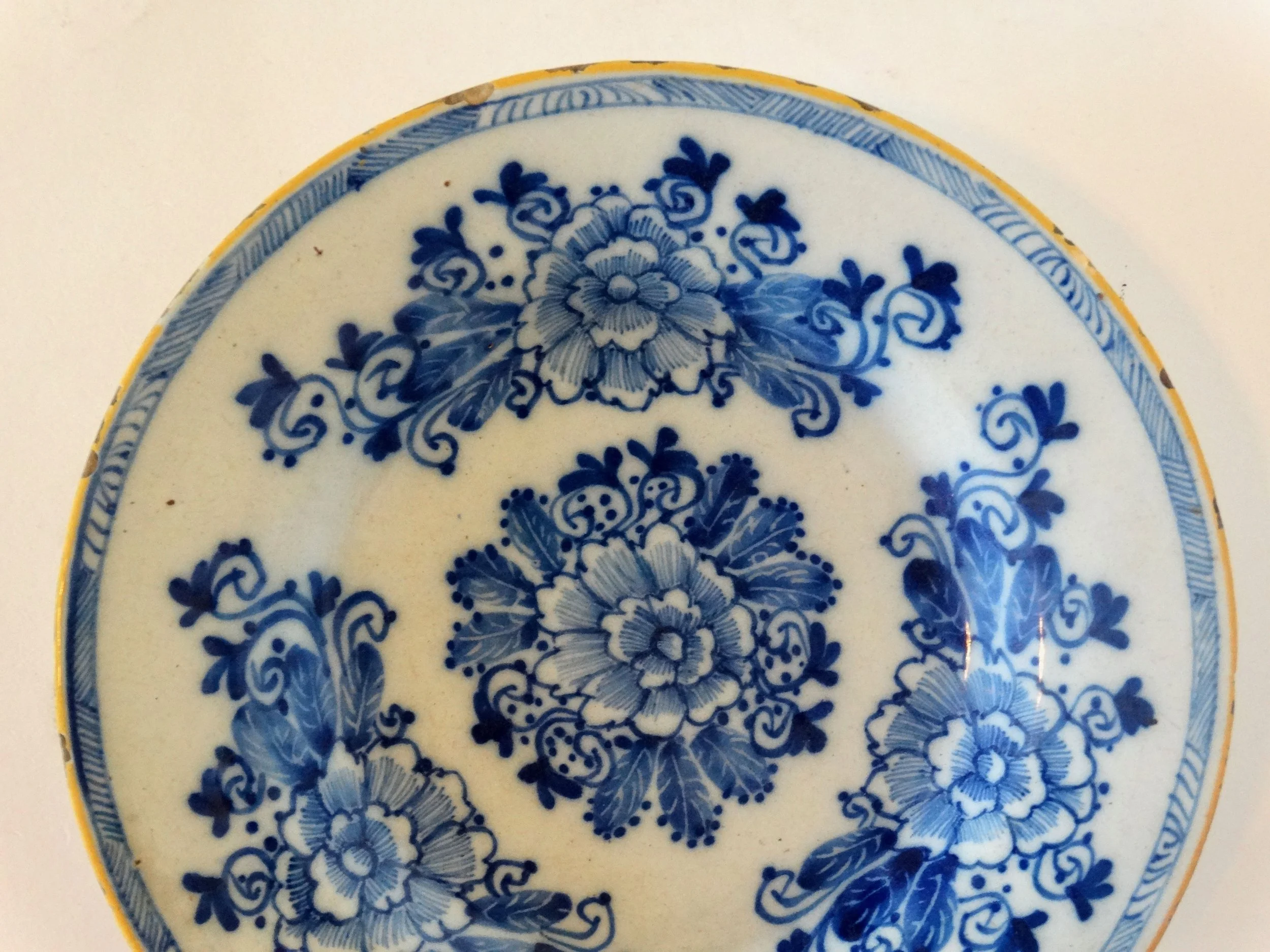 18th-century Dutch Delftware plate by Porcelayne Bijl with hand-painted floral design in blue.