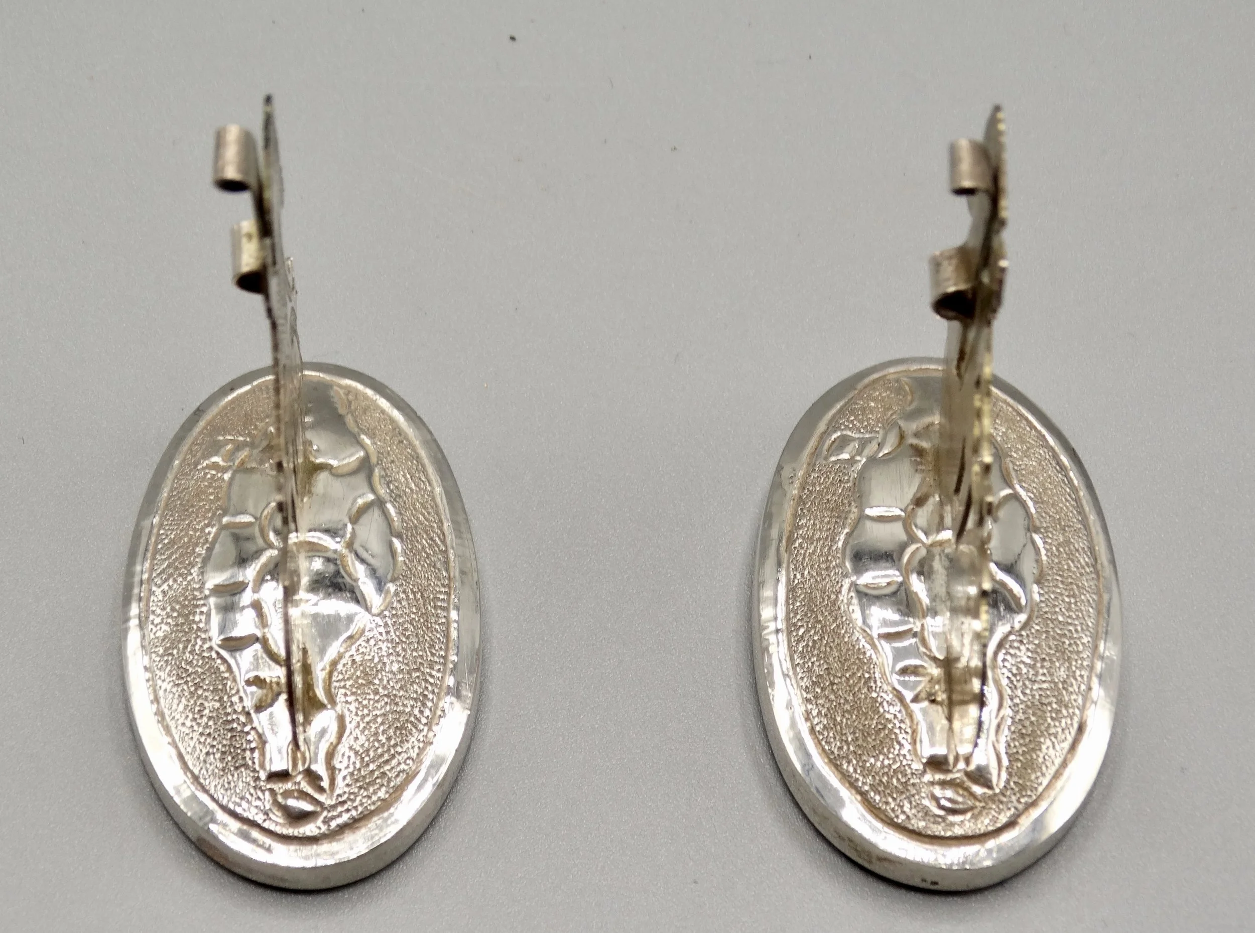 Side view of Chinese export sterling rickshaw place card holders showing figural detail.