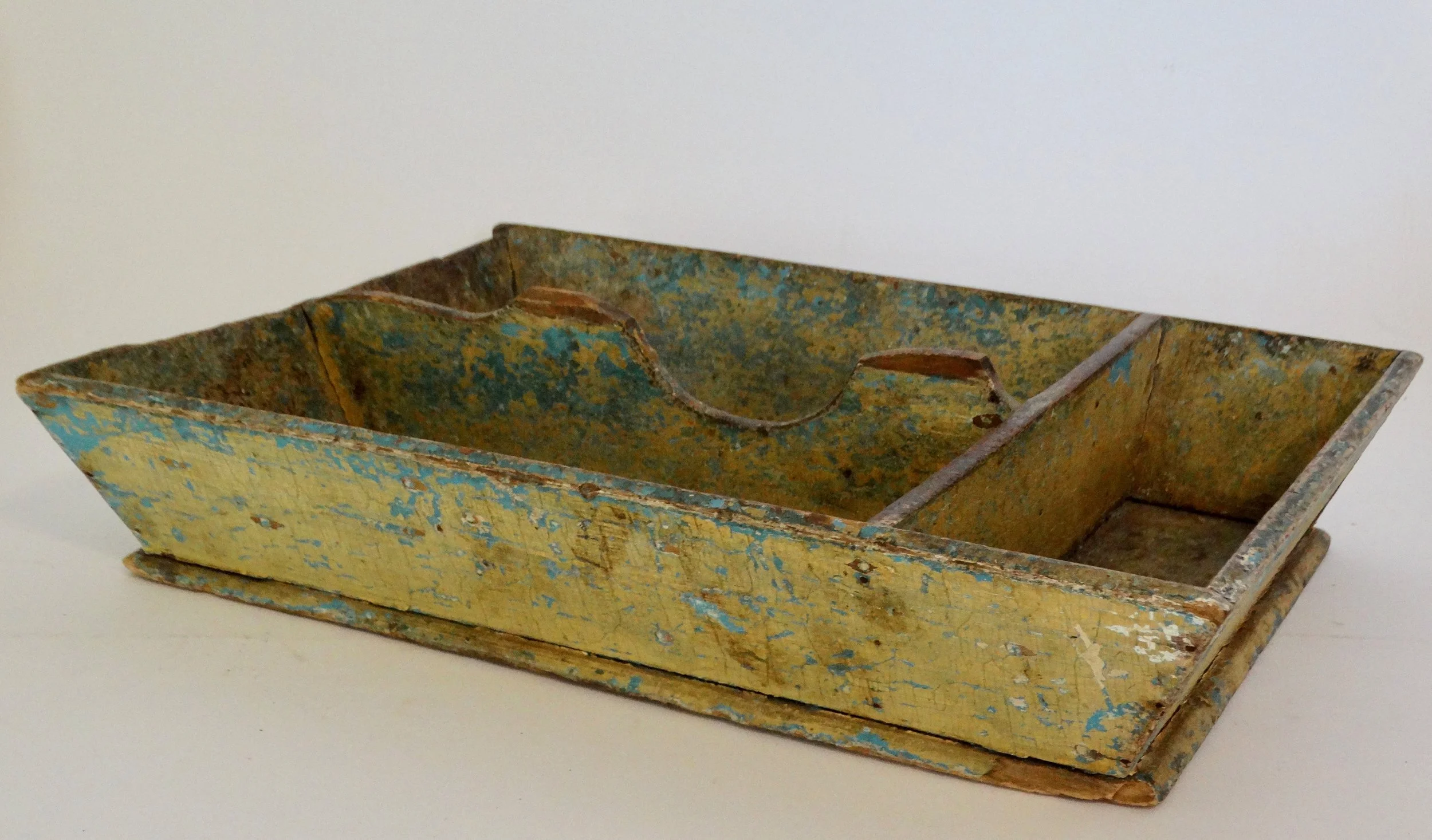 Early 19th-century American primitive cutlery tray in mustard colored paint with canted sides and protruding base.