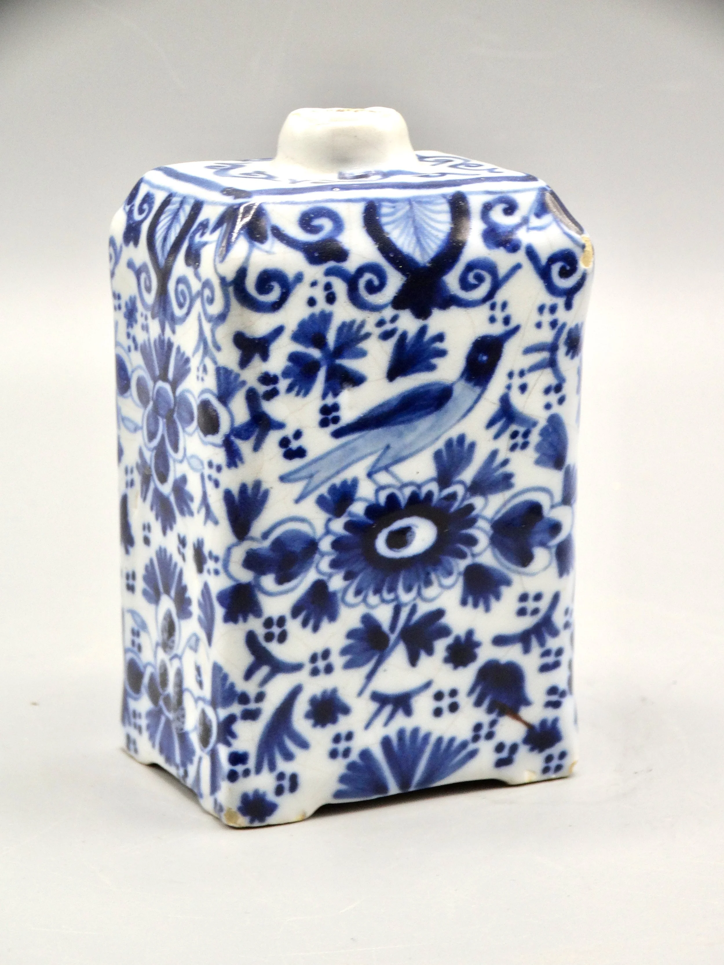 19th-century English Delft tea caddy with hand painted rampart lions, crown coat of arms, bird, and floral motifs.
