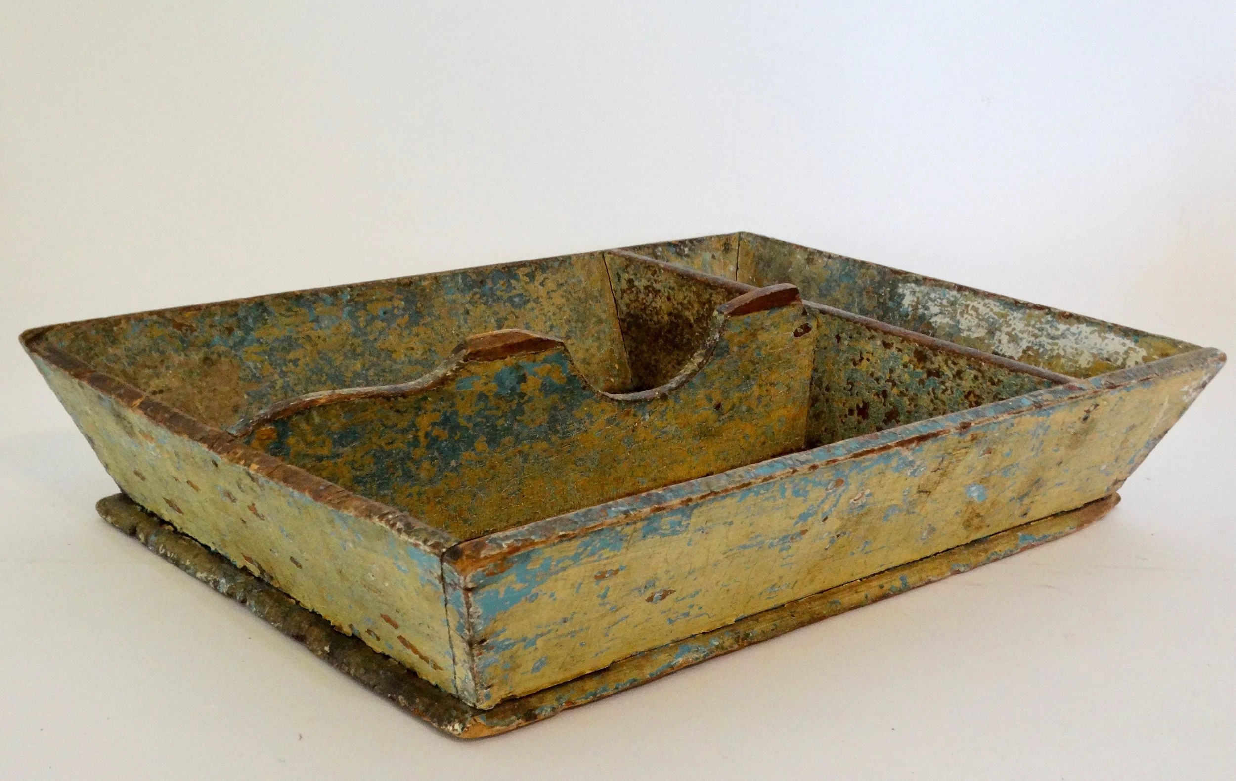 Early 19th-century American primitive cutlery tray in mustard colored paint with canted sides and protruding base.