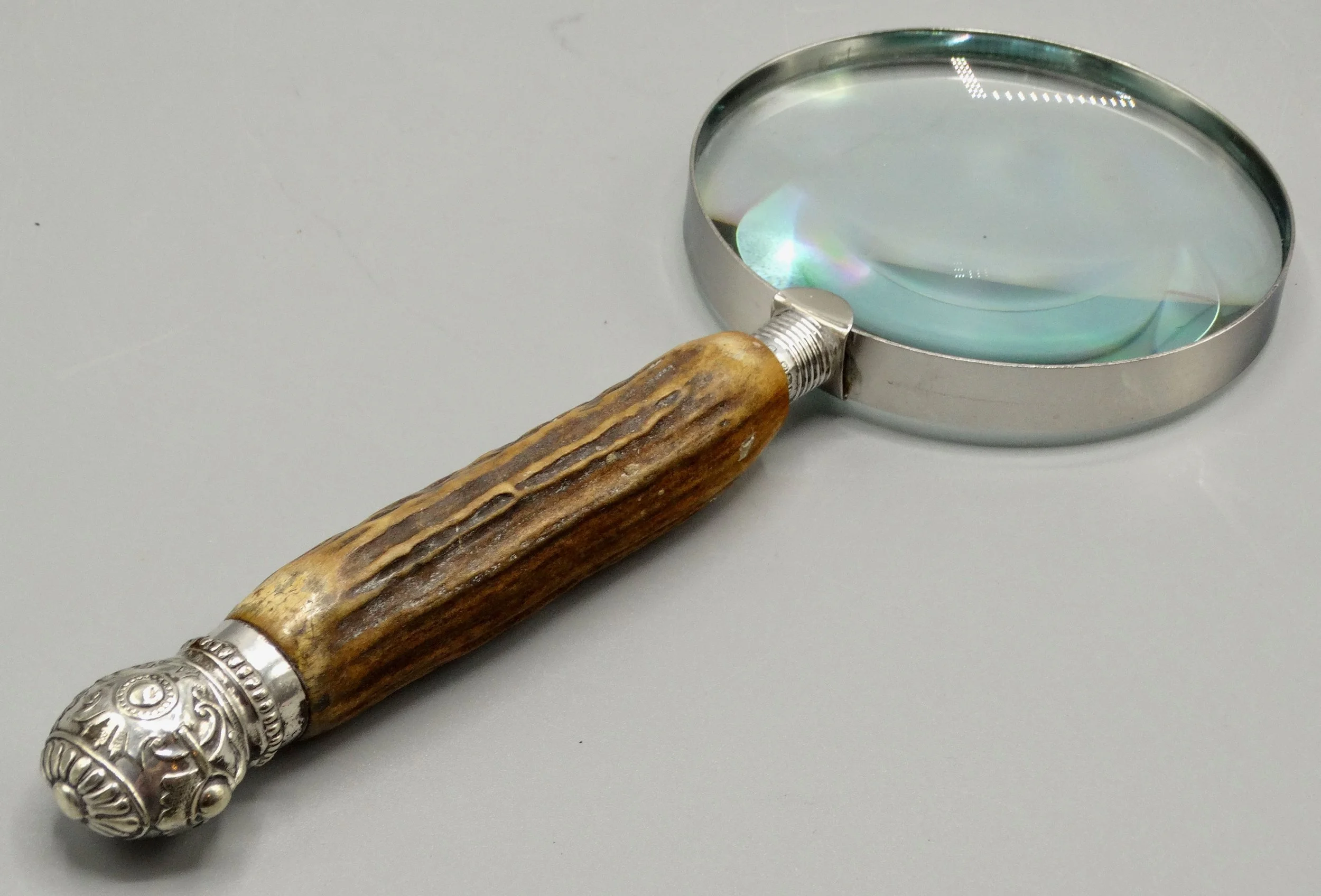 Antique English magnifying glass with natural stag horn handle and sterling silver mounts, hallmarked 1919