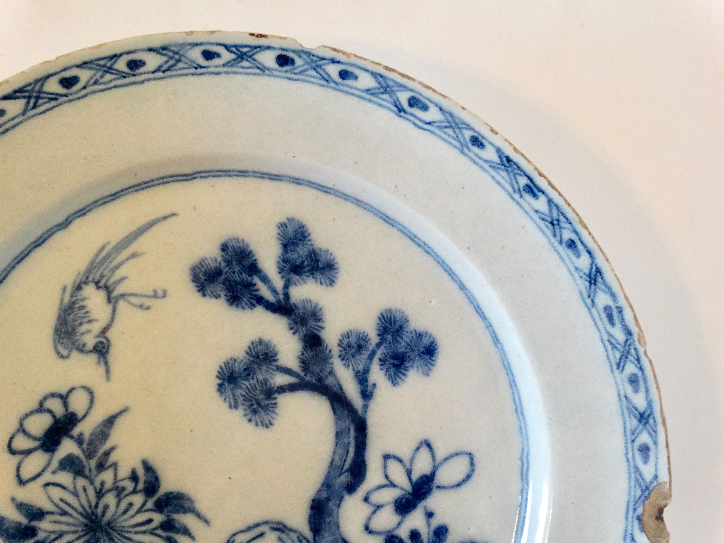Rim detail of antique Delft blue and white chinoiserie charger.