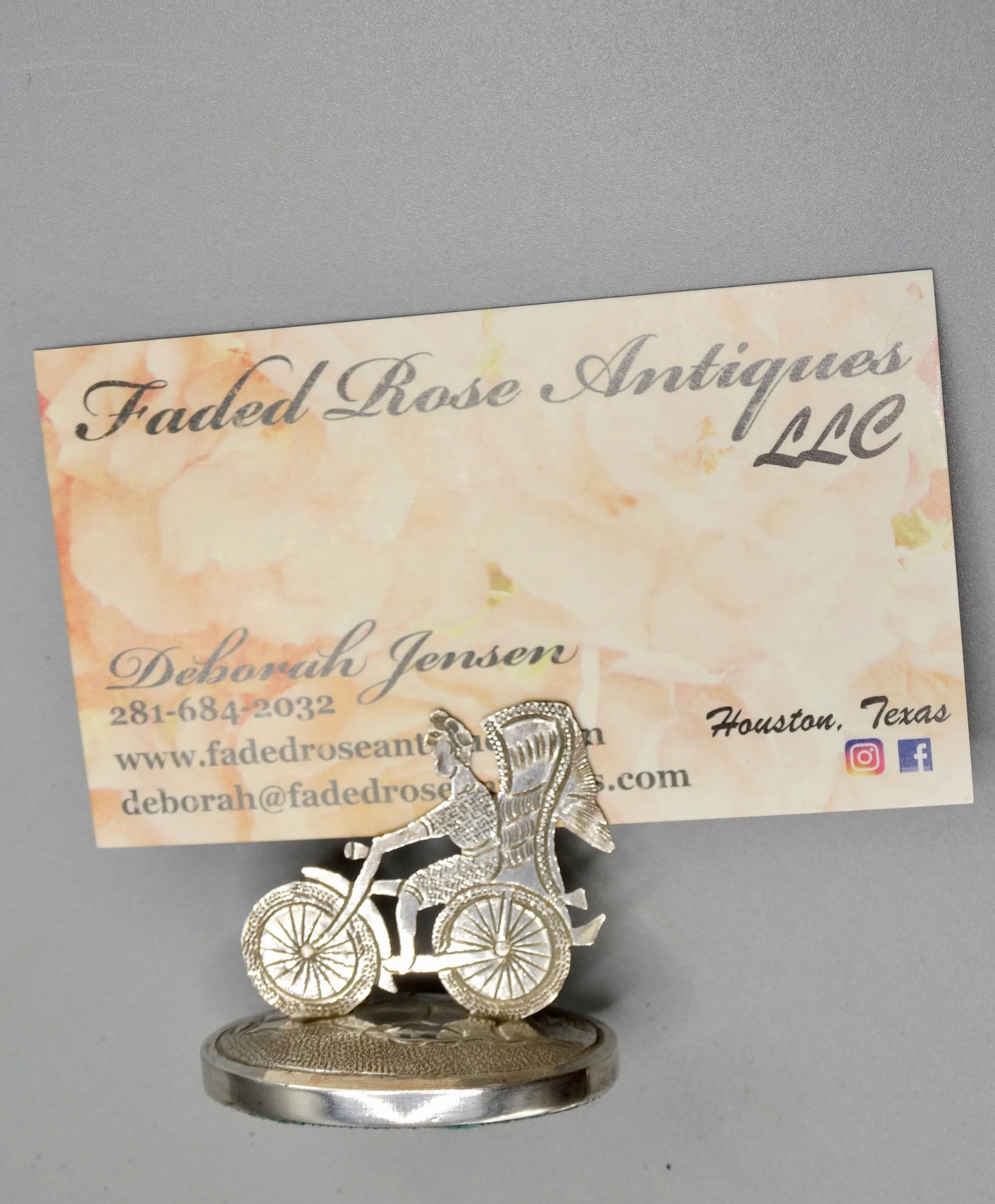 Close-up of finely handcrafted rickshaw and figure on Chinese sterling place card holder.