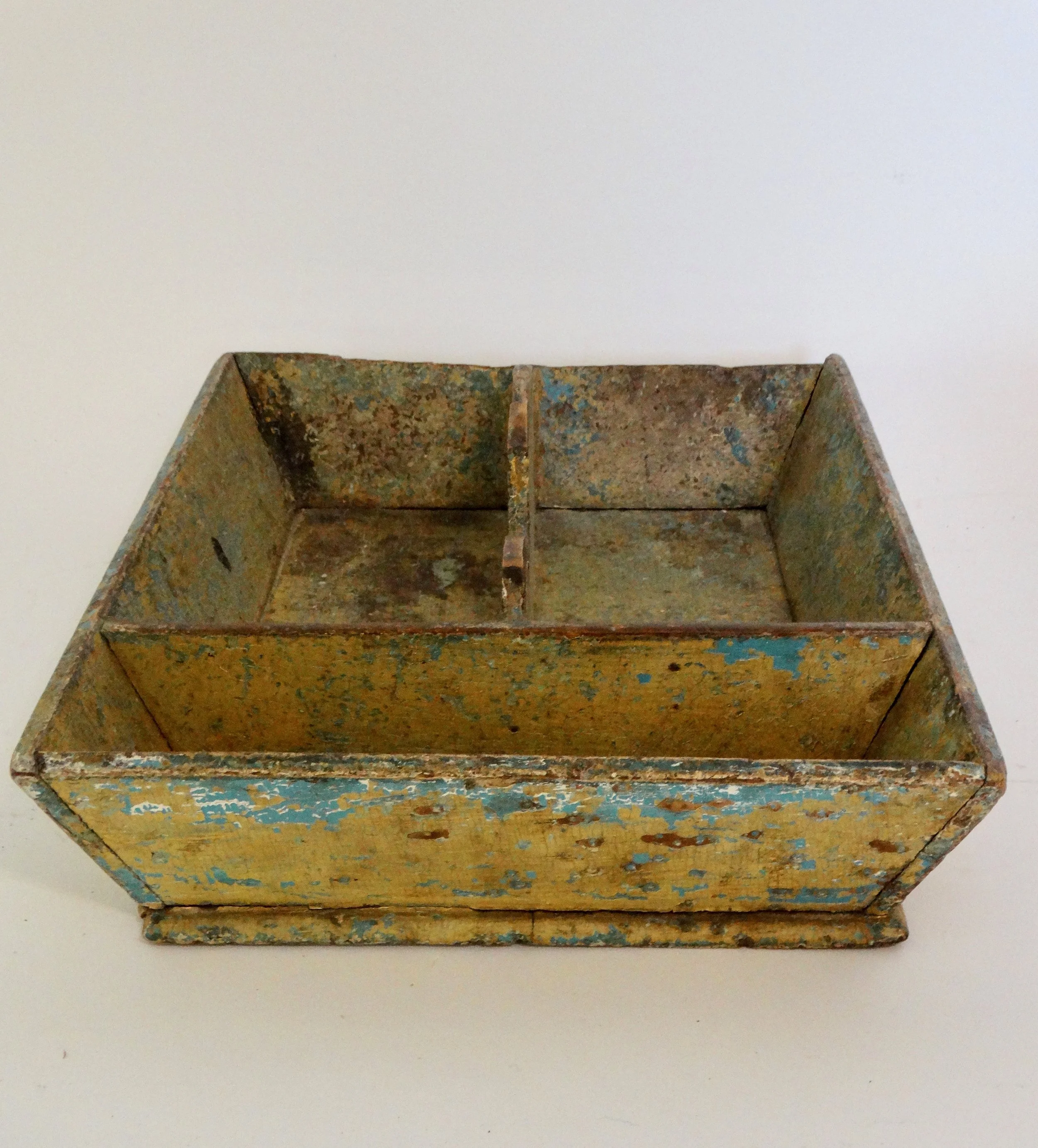 Early 19th-century American primitive cutlery tray in mustard colored paint with canted sides and protruding base.