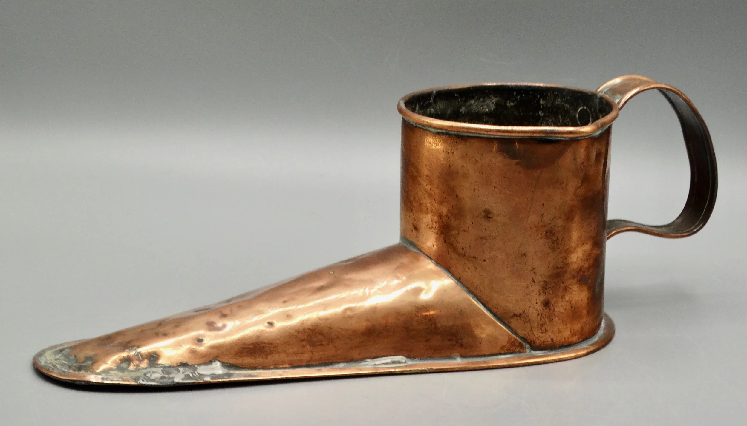Side view of antique English copper ale warmer shaped like a boot, handcrafted 19th-century piece