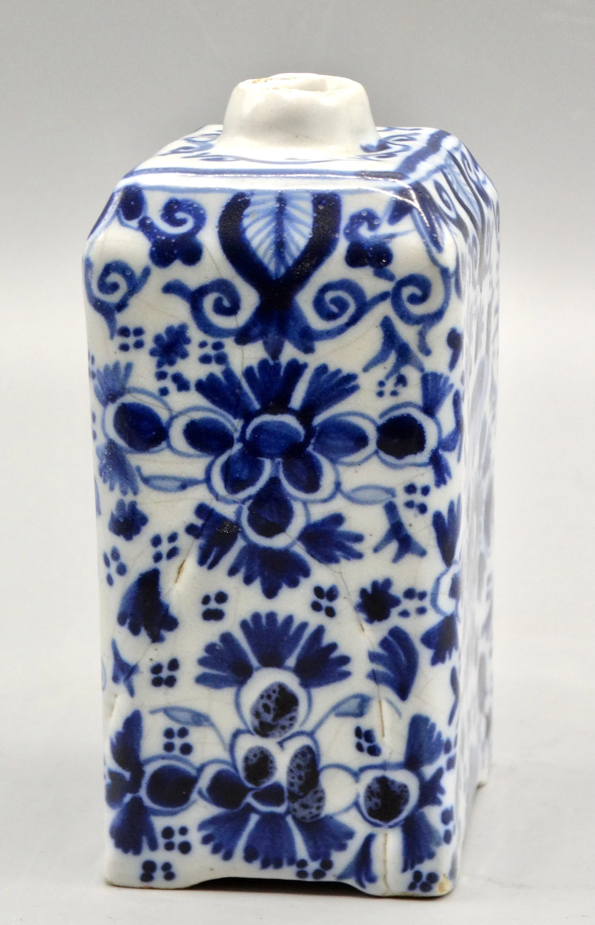 Side view of 19th-century English Delft tea caddy showing form and tin-glazed surface.