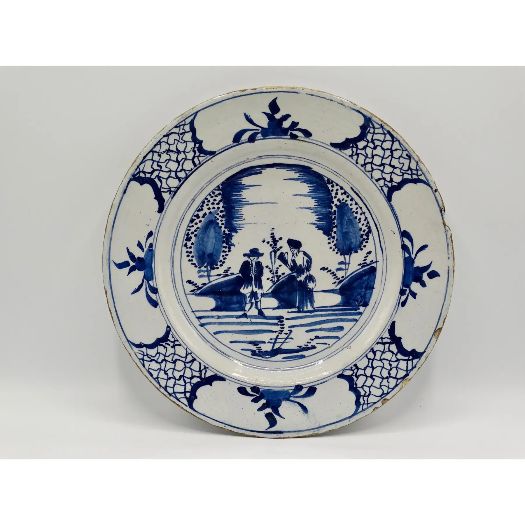 18th century Dutch Delft chinoiserie charger with two figures in blue and white.