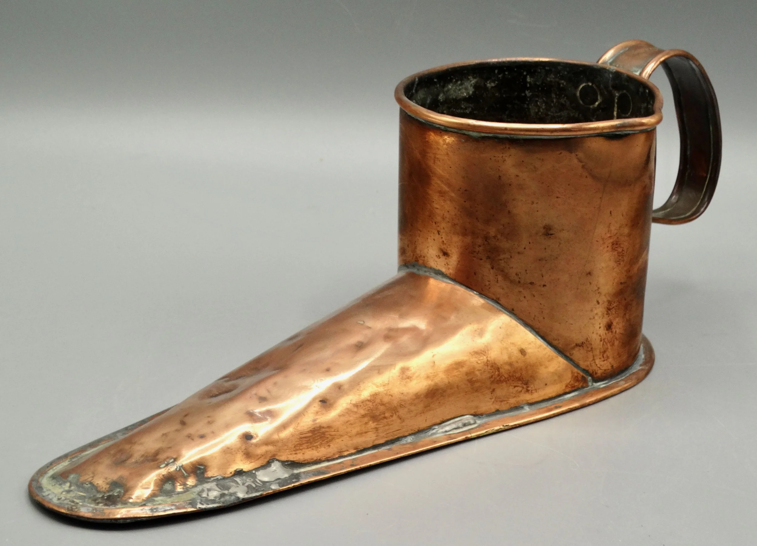 Side view of antique English copper ale warmer shaped like a boot, handcrafted 19th-century piece