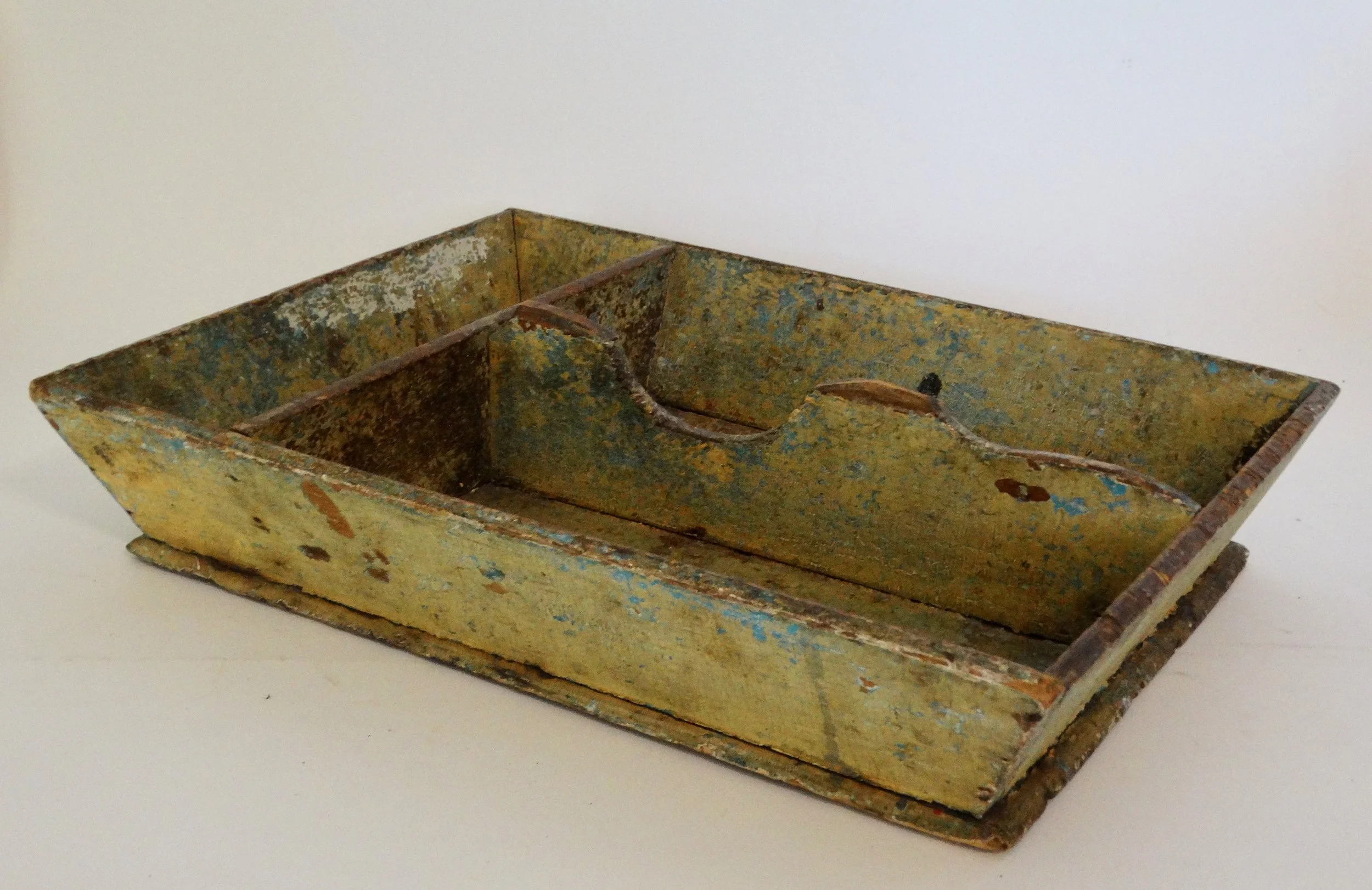 Early 19th-century American primitive cutlery tray in mustard colored paint with canted sides and protruding base.