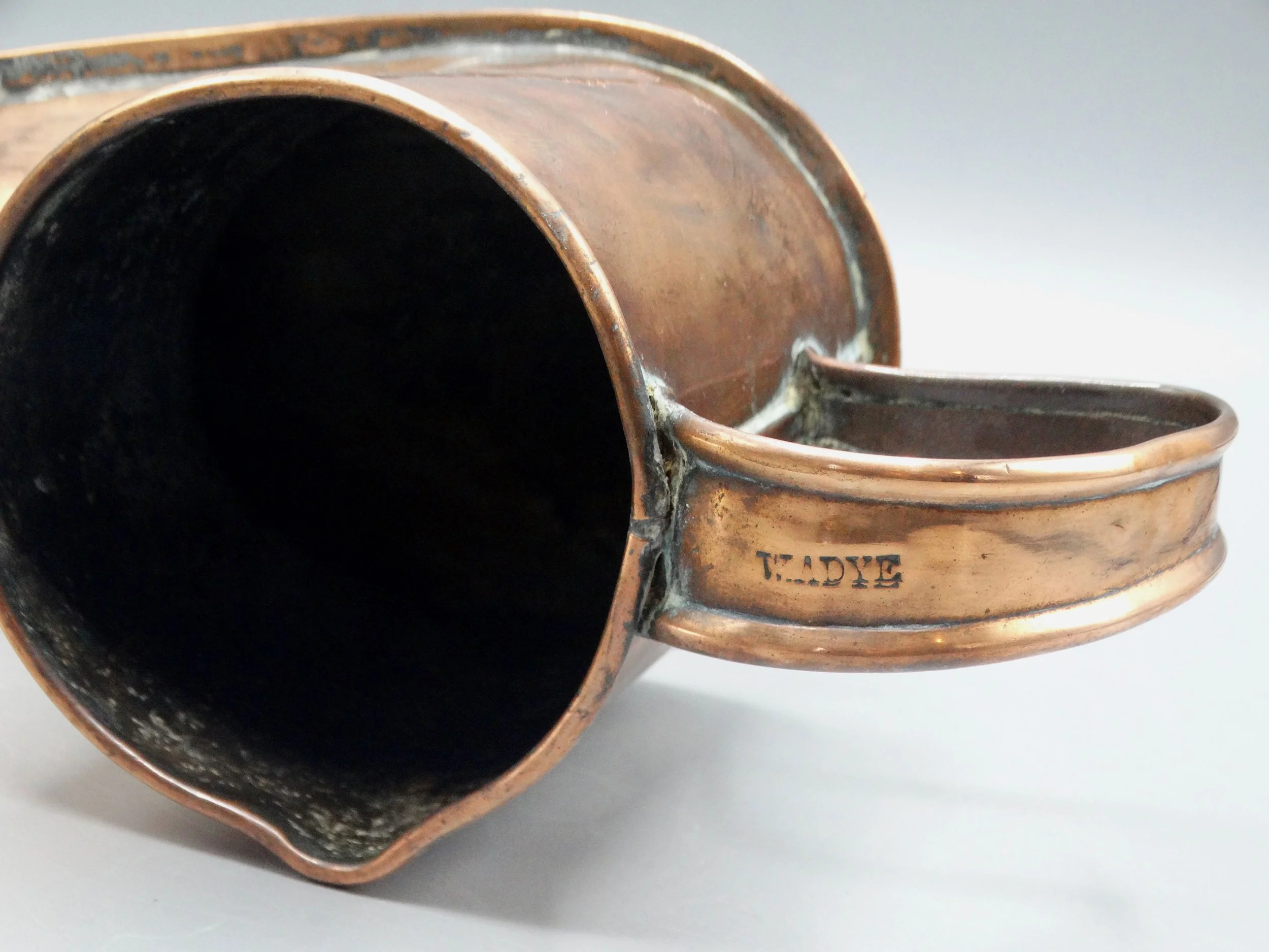 Top view of 19th-century English copper boot ale warmer, showing open mouth and handcrafted details